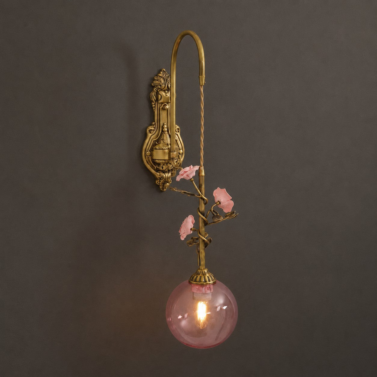 The wall sconce installed on a dark, moody wall for contrast.