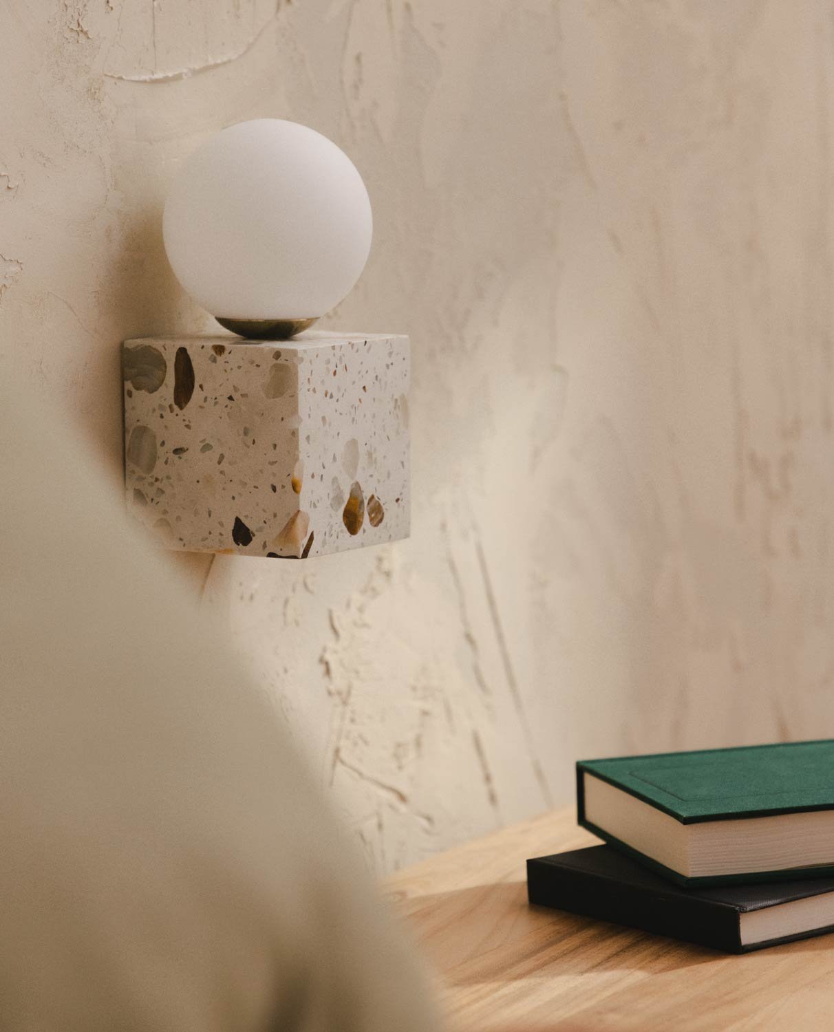 Close-up view of the white terrazzo texture on the cube wall sconce.