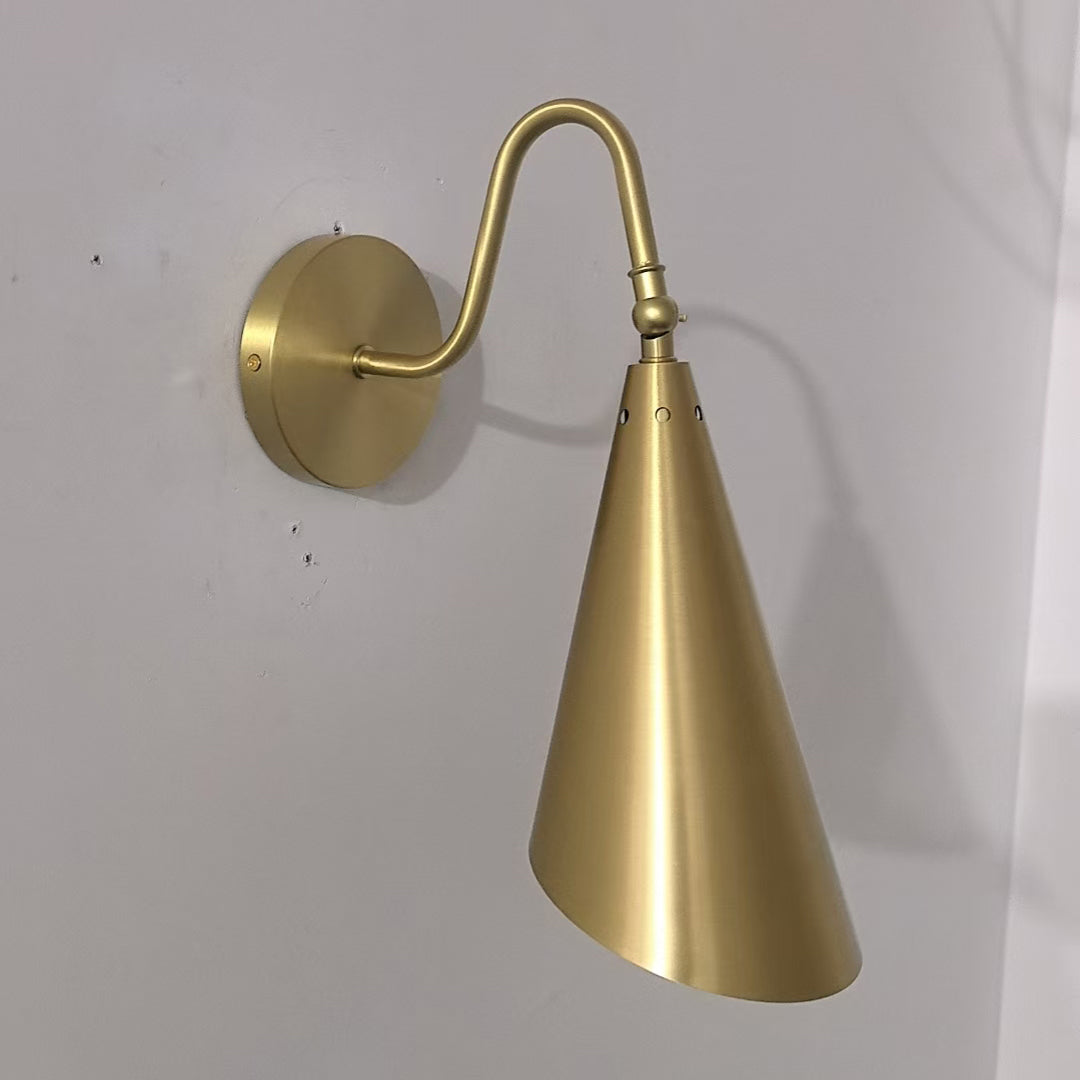 Lifestyle image showing the brass lamp over a bedside table.