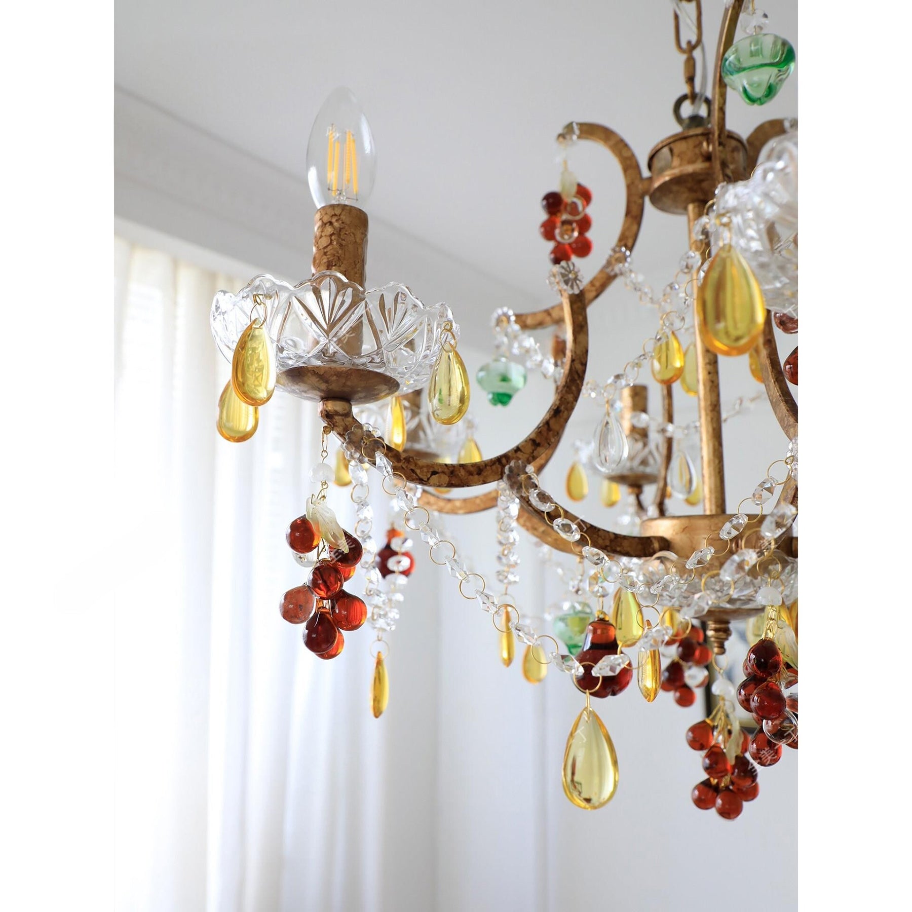 The chandelier unlit, displaying the vibrant colors of the crystal decorations.