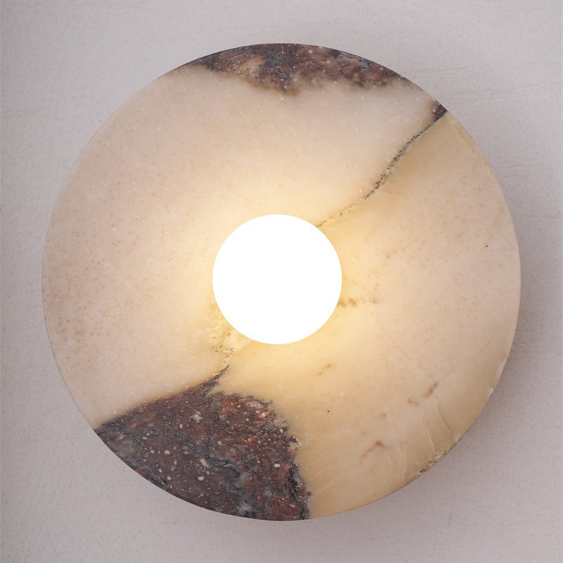Detail of the brass hardware on a red marble wall lamp.