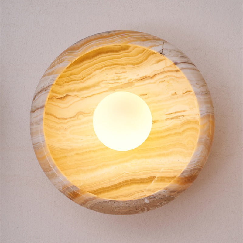 Front view of a circular green marble wall lamp.