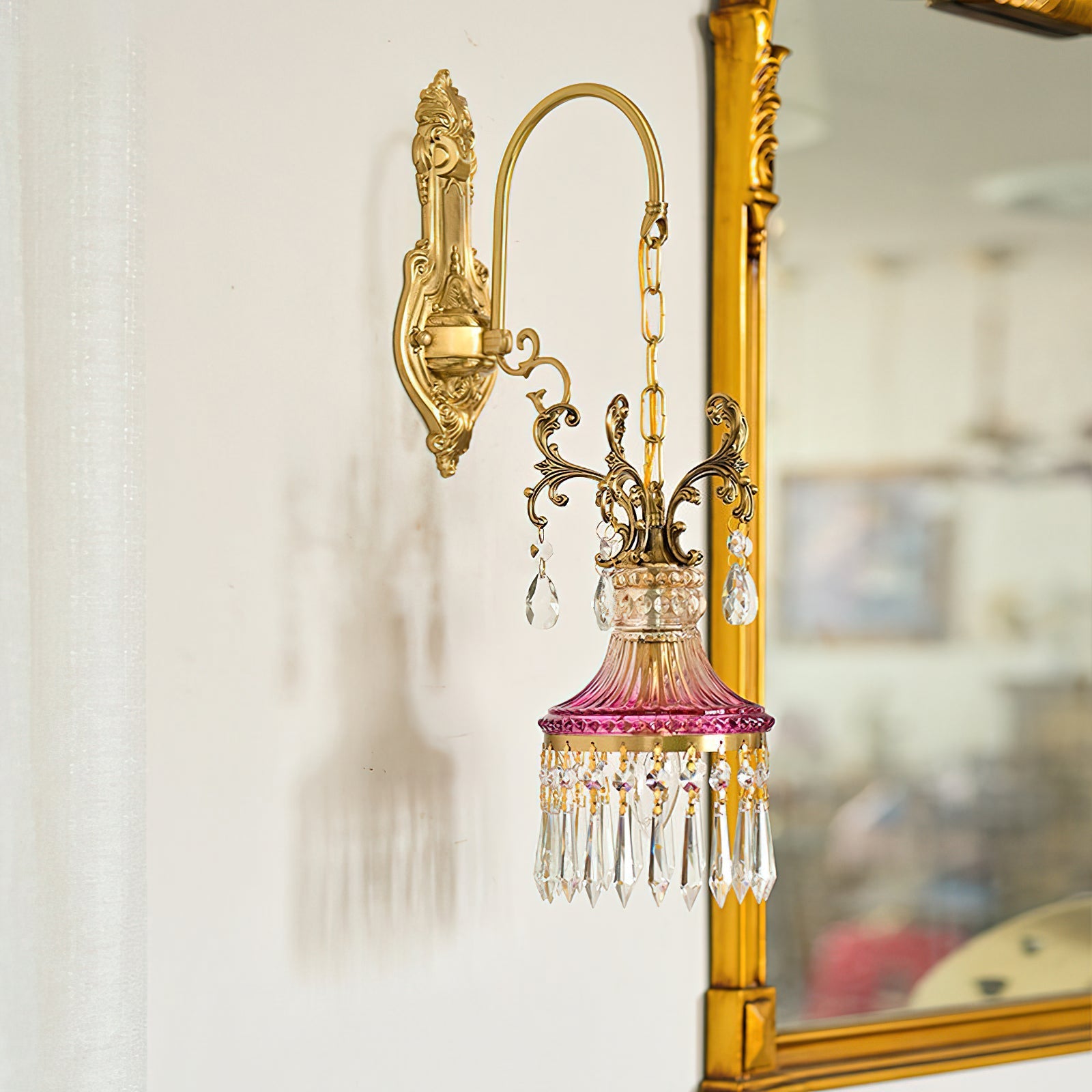 The antique brass gooseneck arm of the wall sconce.