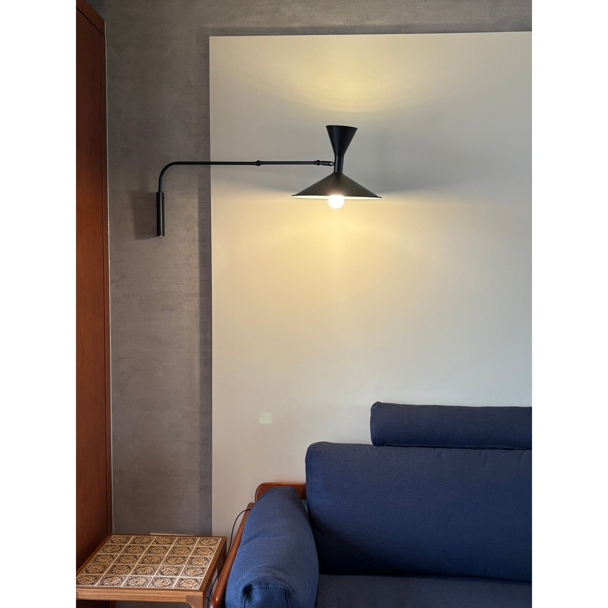 Lifestyle image of the white sconce in a minimalist bedroom.