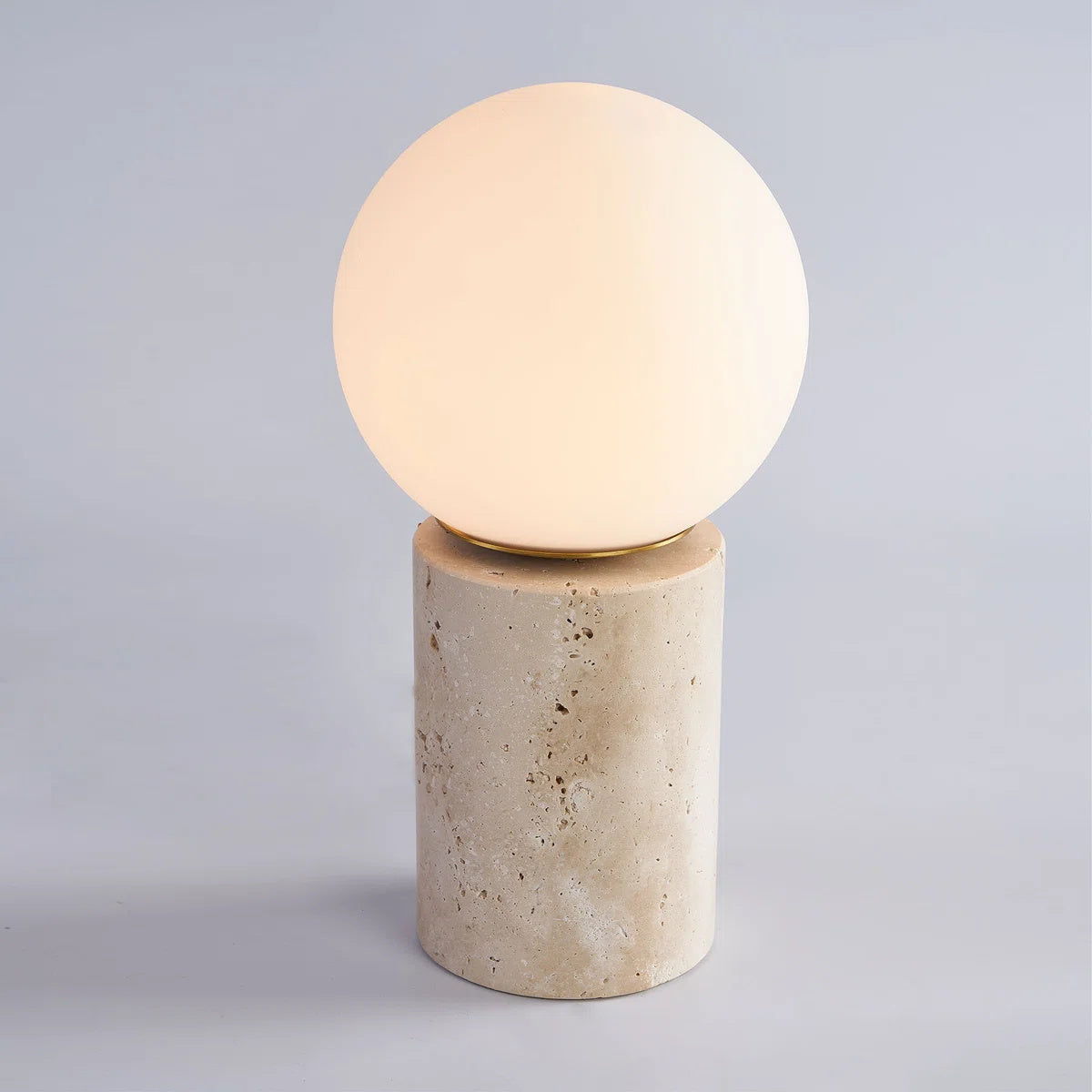 The lamp styled on a stack of books on a side table.