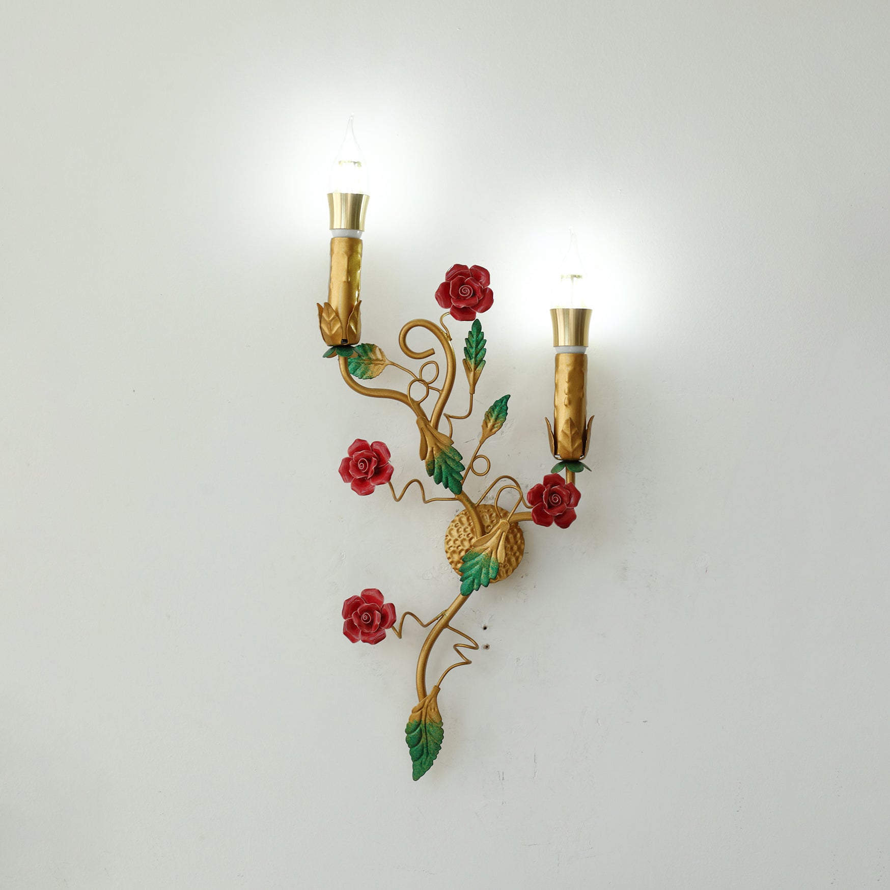 The wall lamp from a low angle, highlighting the candle lights.