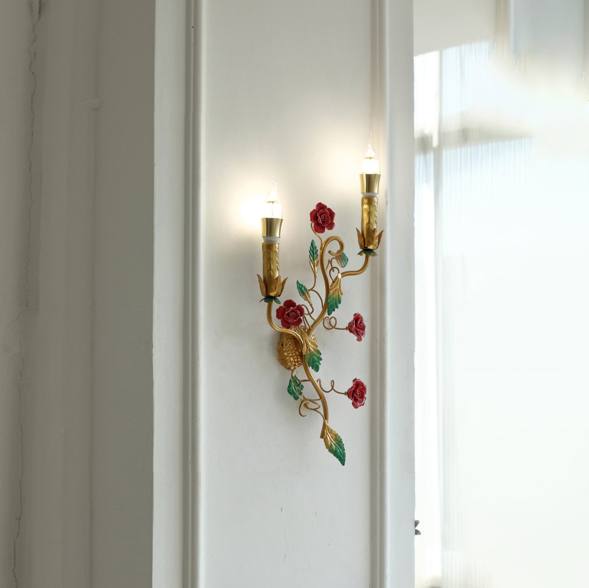 Close-up of the crimson ceramic rose on the Mechini wall lamp.