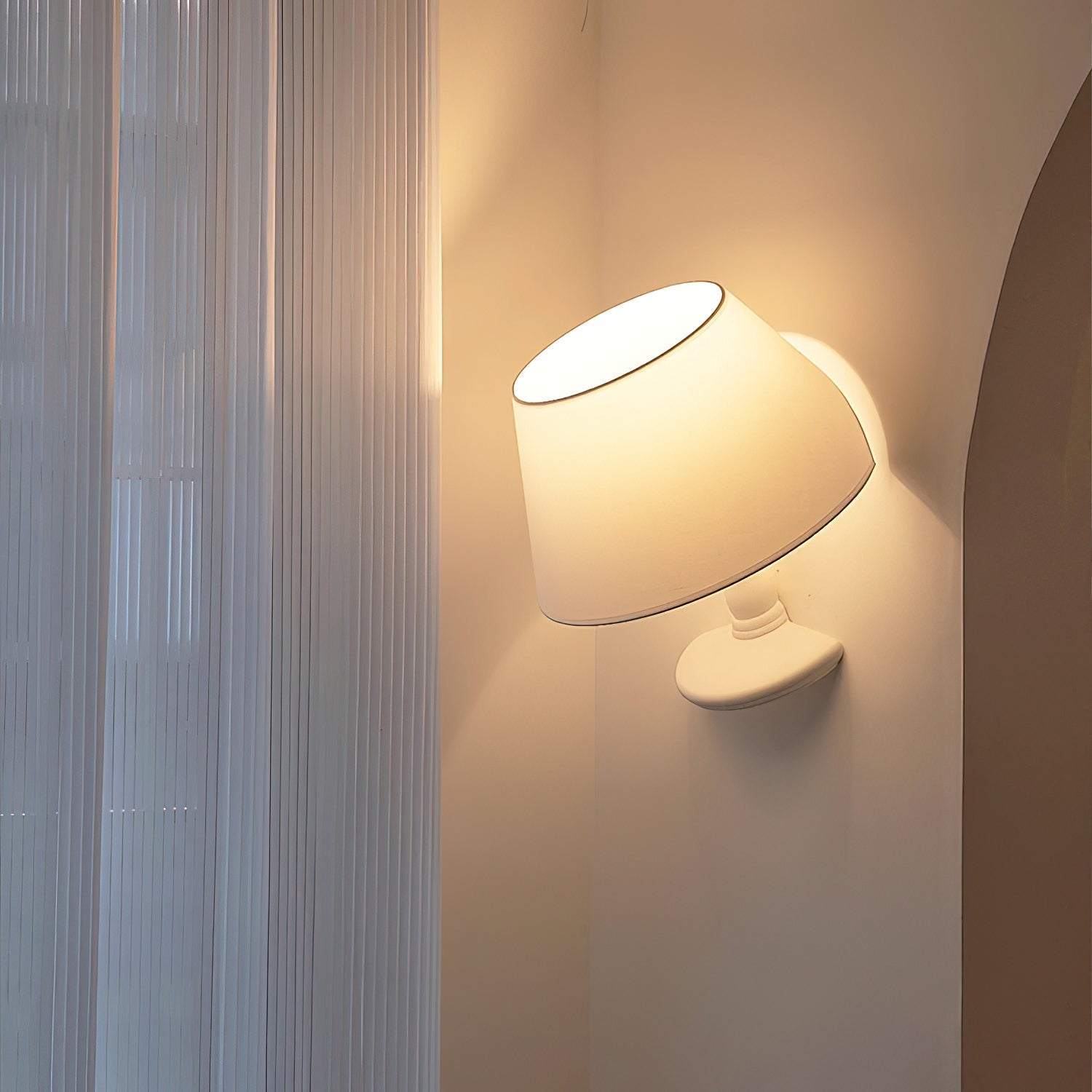 Close-up of the white fabric lampshade of the Melampo Wall Lamp.