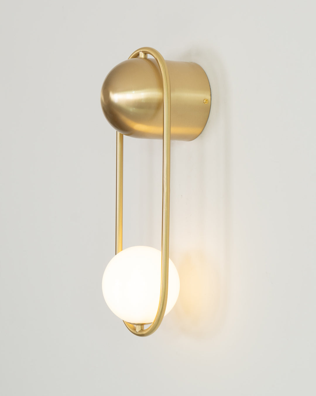 The white Mila Wall Lamp in a bright, airy entryway.