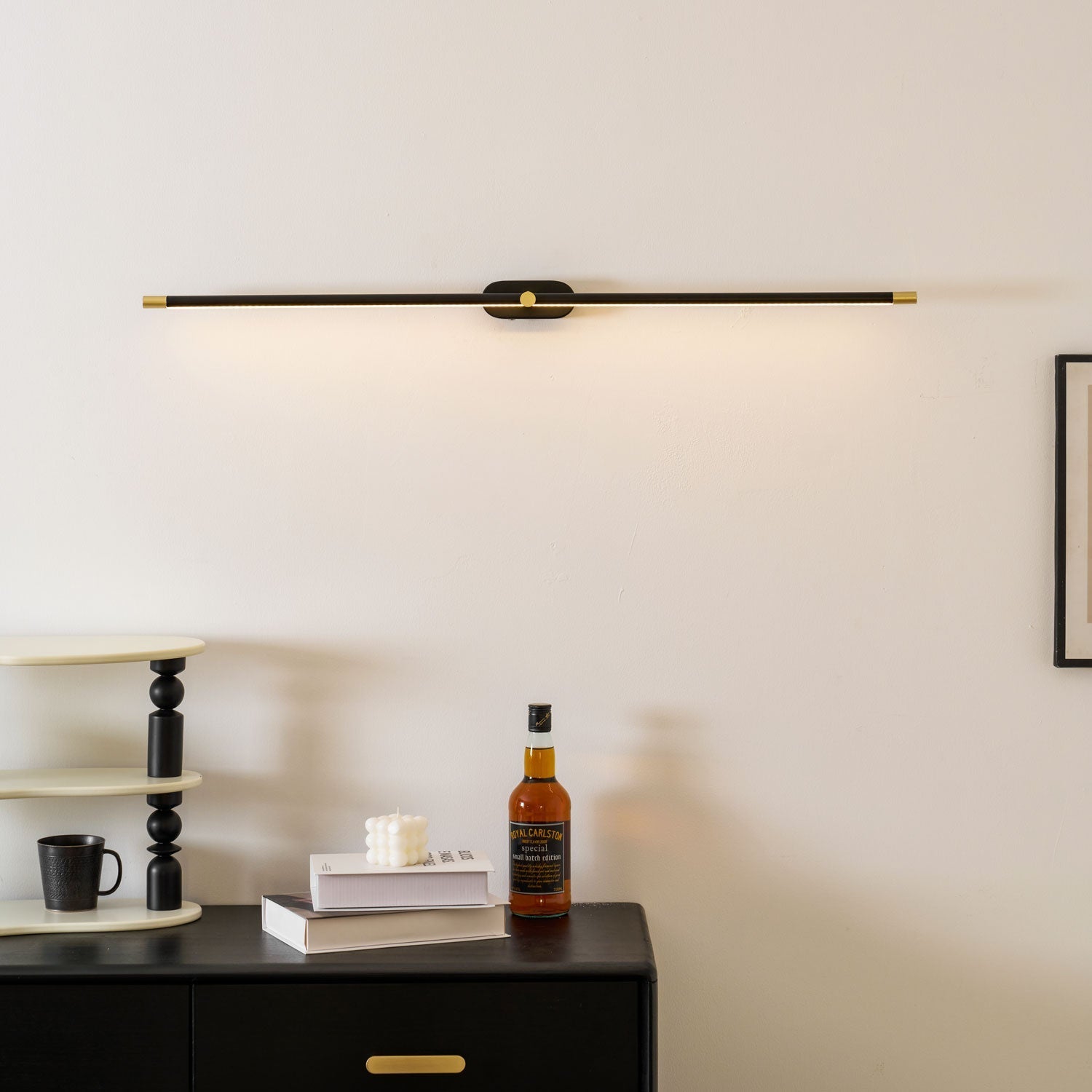 Lifestyle view of the black linear wall lamp in a bedroom.