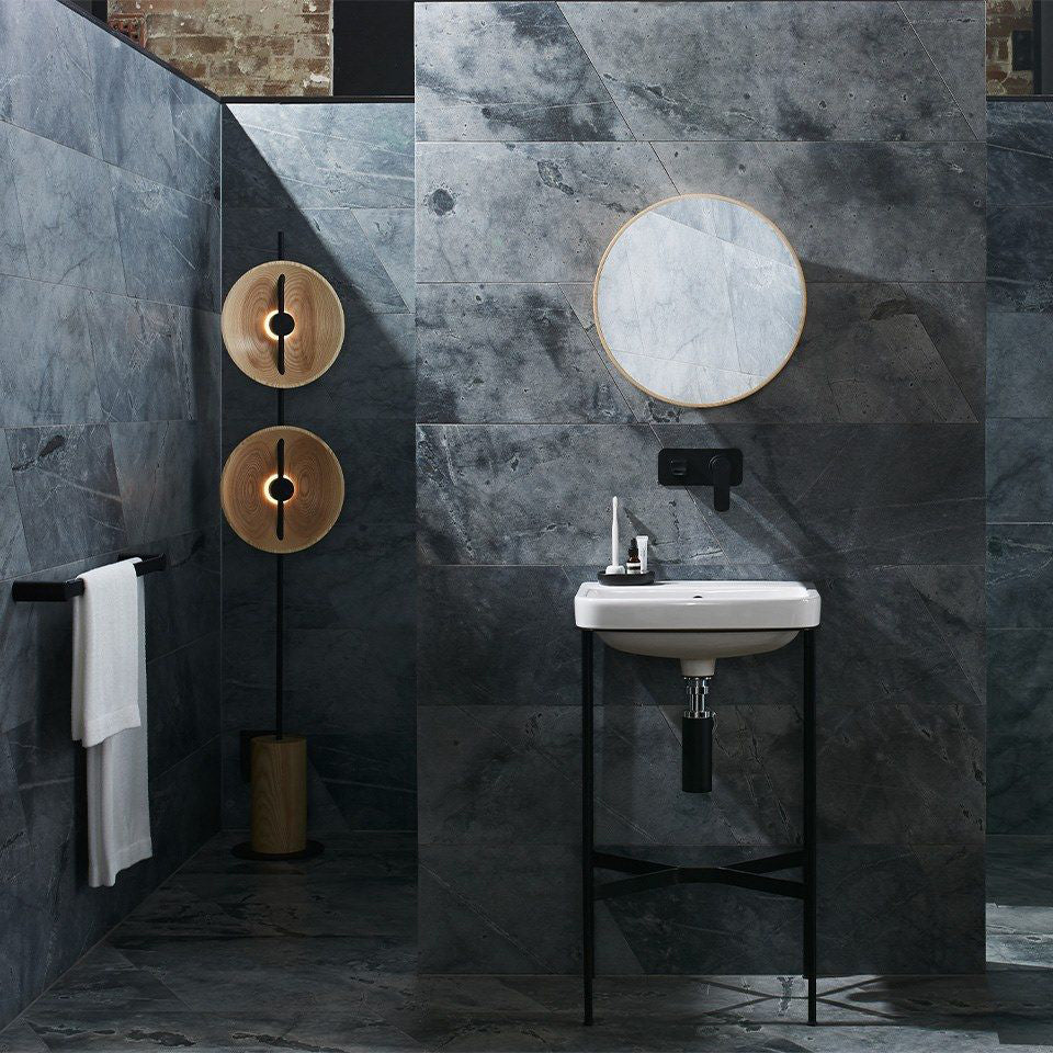 The sleek black iron base and stem of the Mito Floor Lamp.