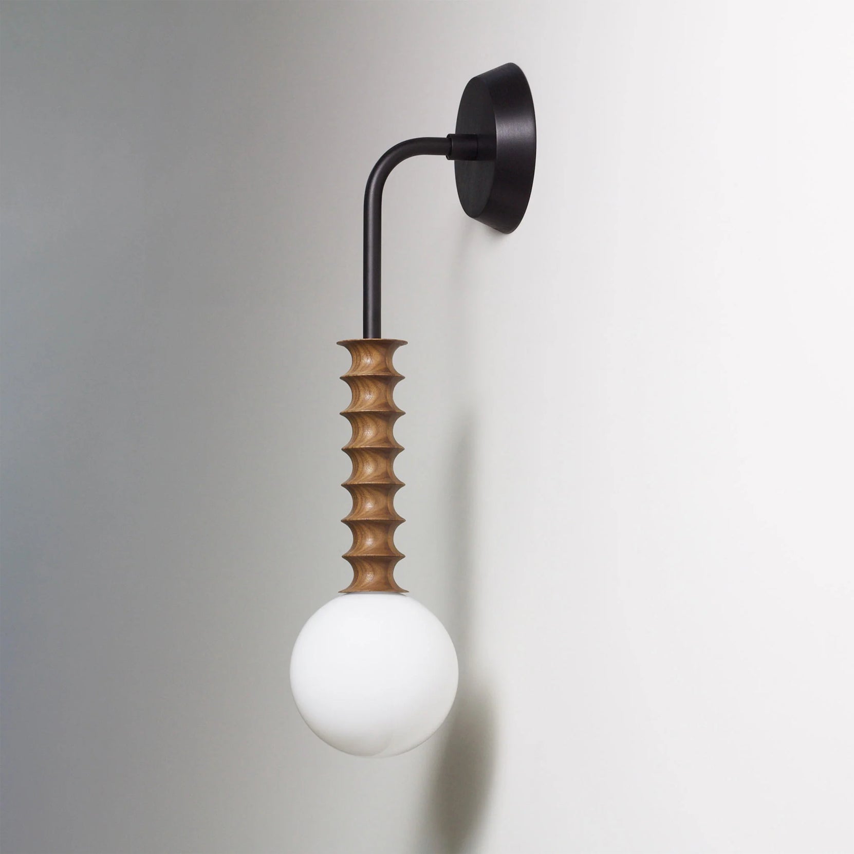 Close-up of the Mobo Wall Lamp's wood and metal components.