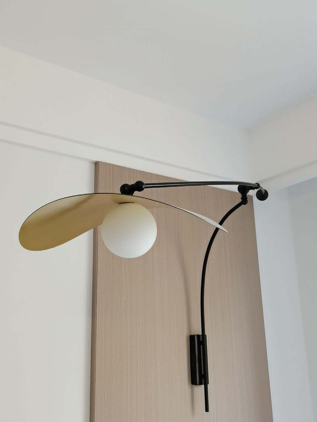 Myrna Wall Lamp casting a warm, ambient glow.