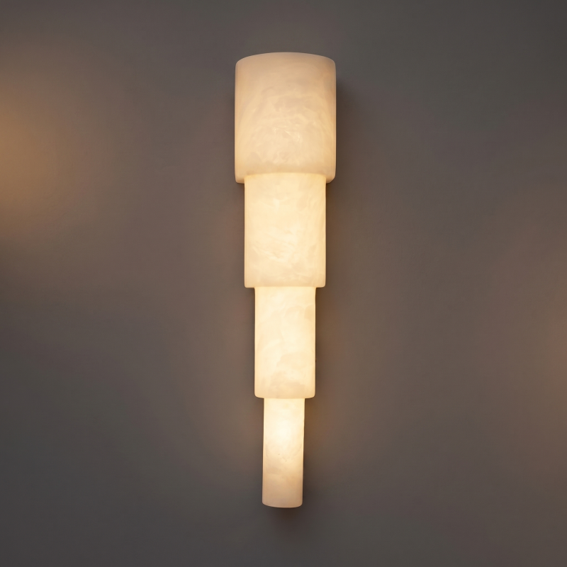 A pair of alabaster wall sconces mounted on either side of a bed.