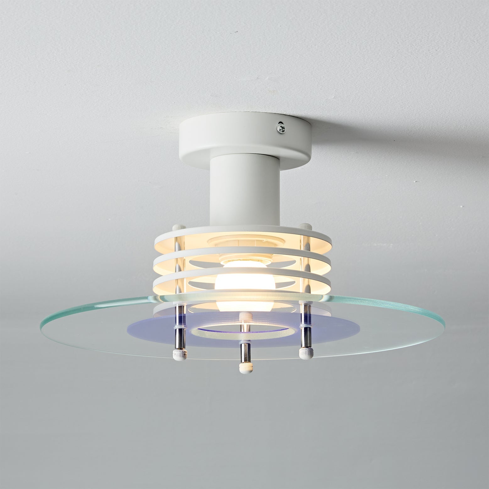 Nello Ceiling Lamp providing a cool, clean glow in a room.