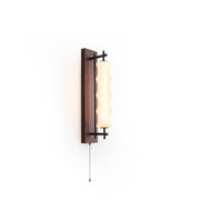 Nesta Wavy Glass Wall Sconce with wood finish against a light wall.