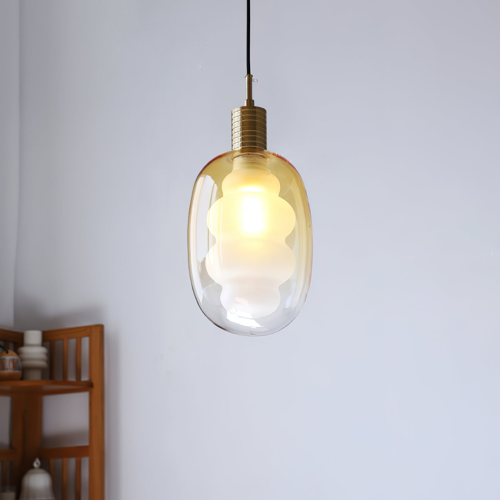 The blue-tinted outer glass shade of the pendant light.