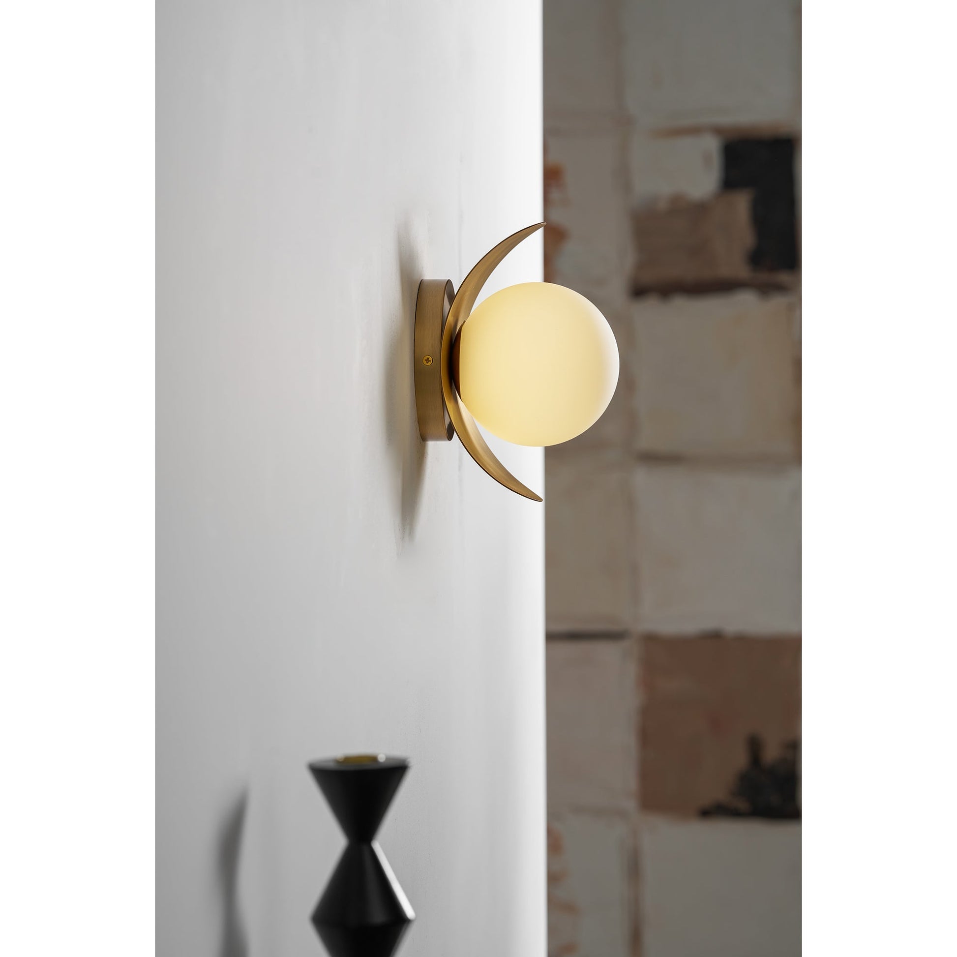 Detailed shot of the texture on the antique brass finish of the Nouvel Wall Lamp.
