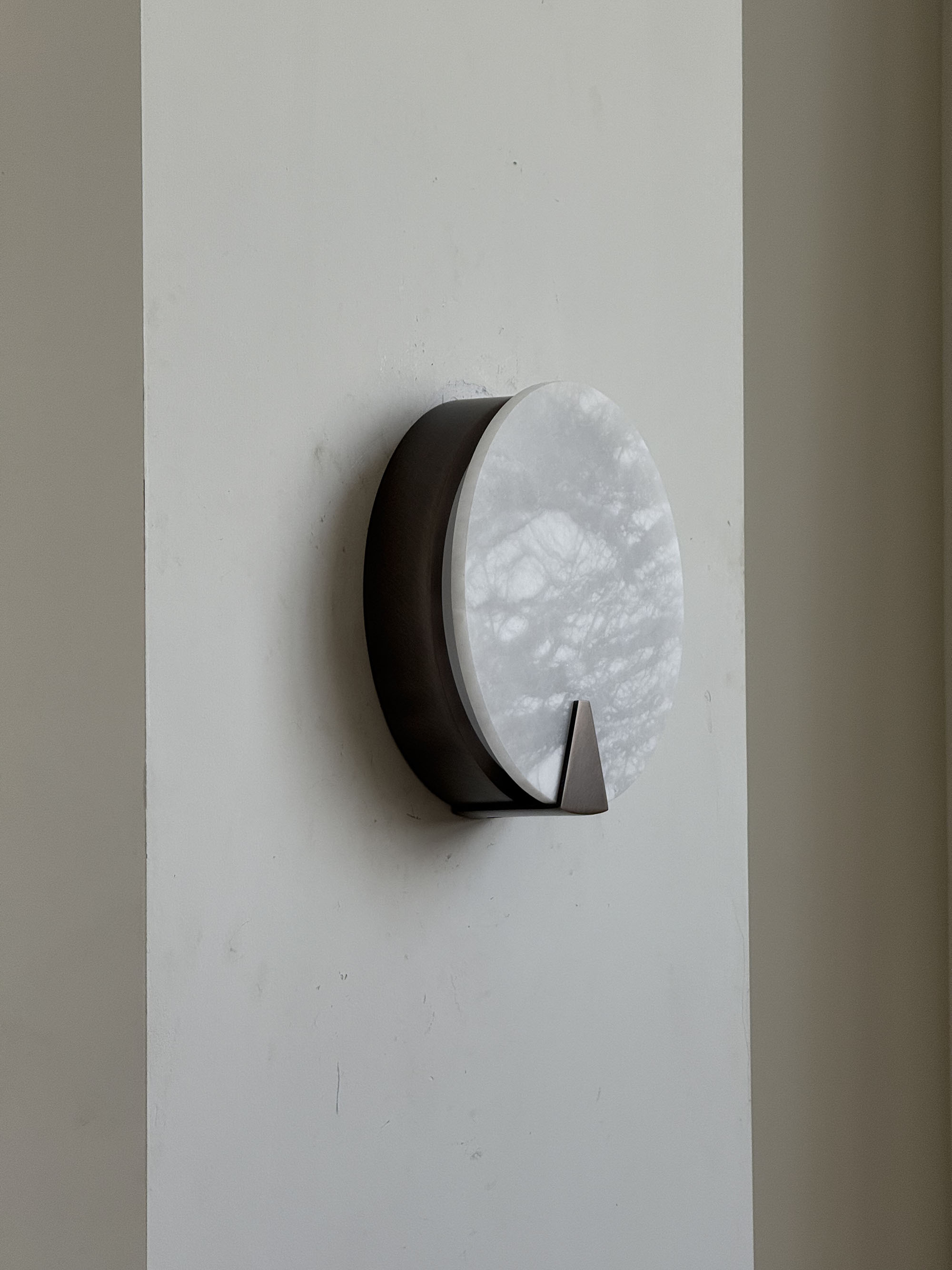 The Ophelia Sconce installed above a bedside table.
