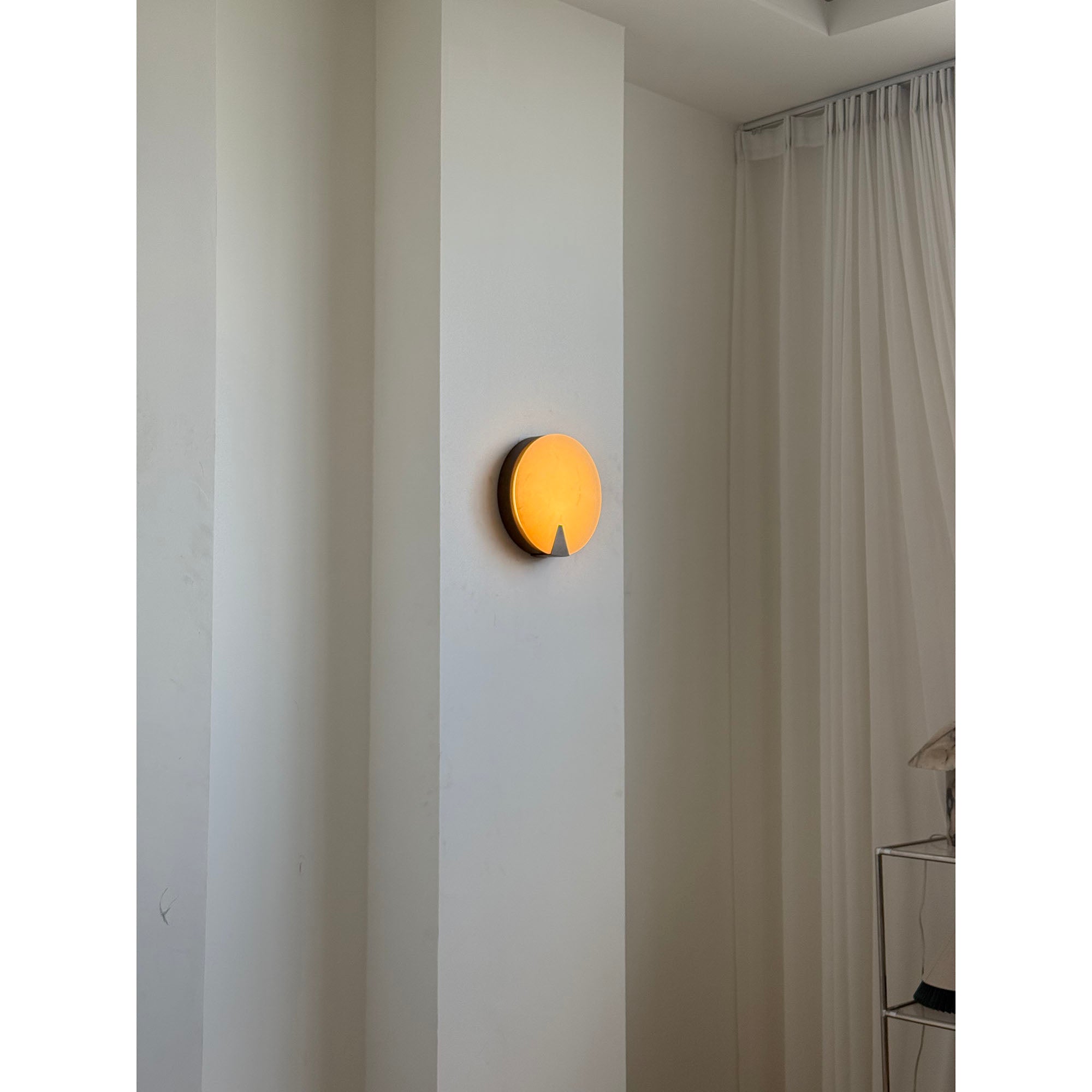 The Ophelia Alabaster Round Sconce in a hotel lobby setting.