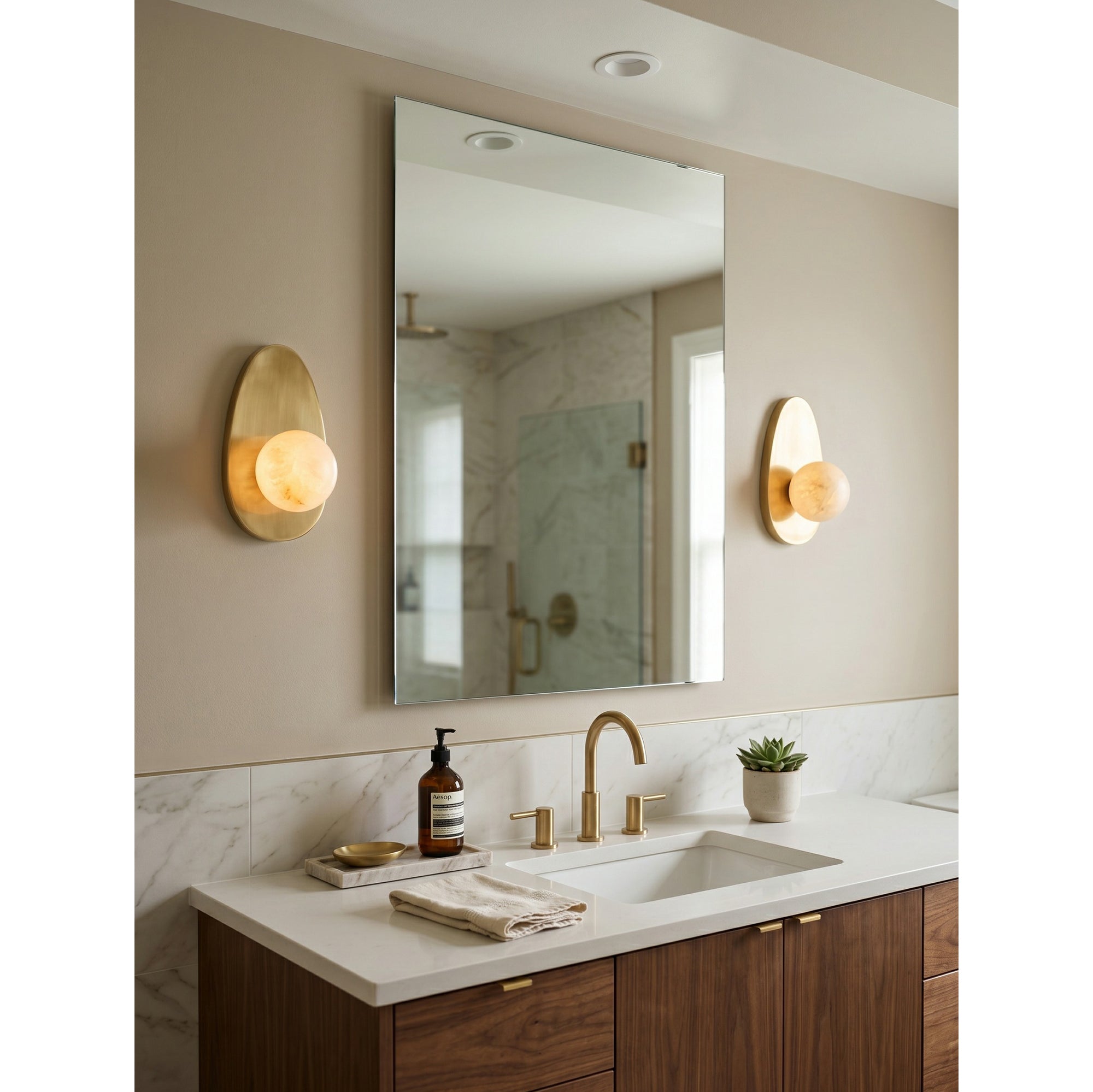 The wall sconce in a transitional-style bathroom.