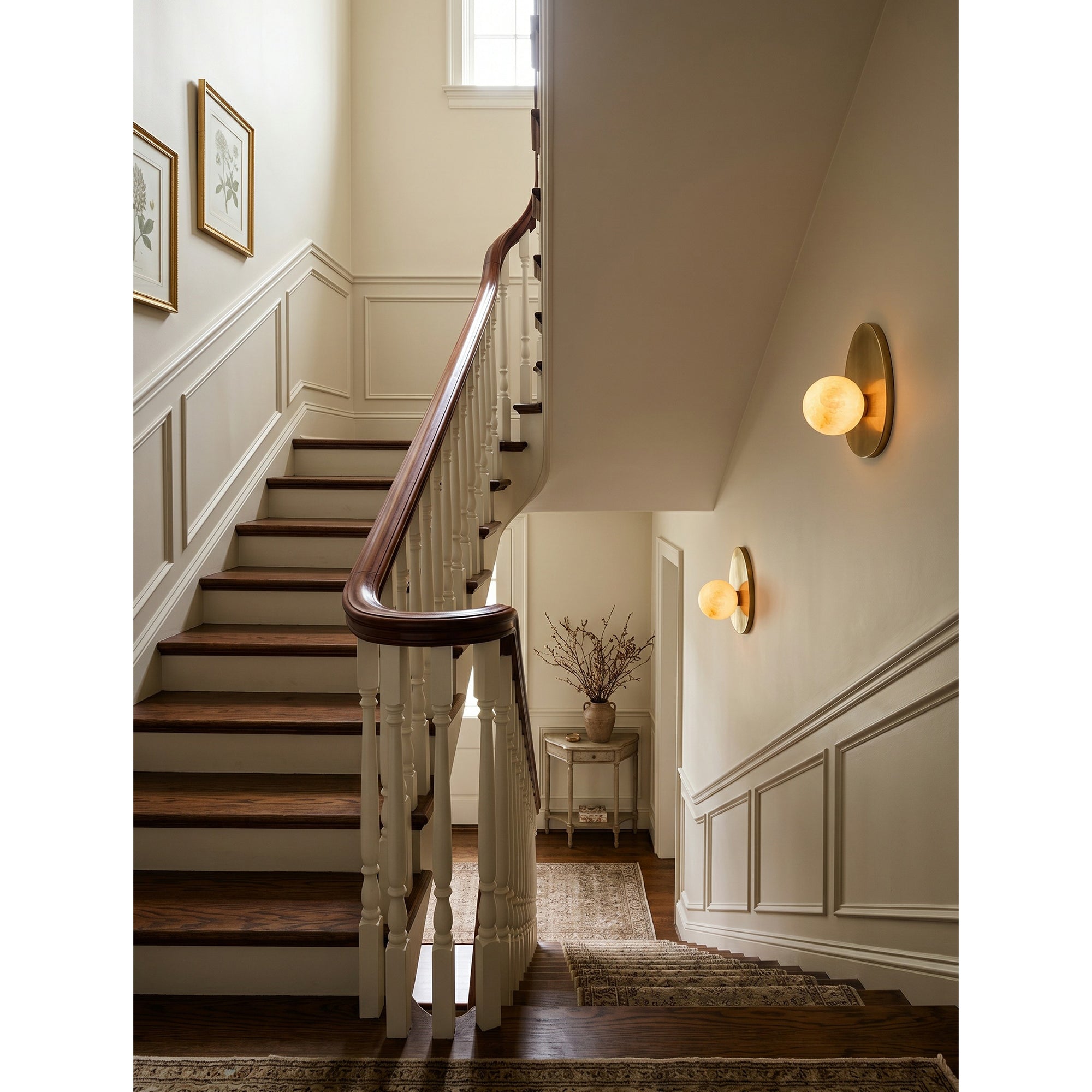 The light pattern cast on the wall by the illuminated sconce.