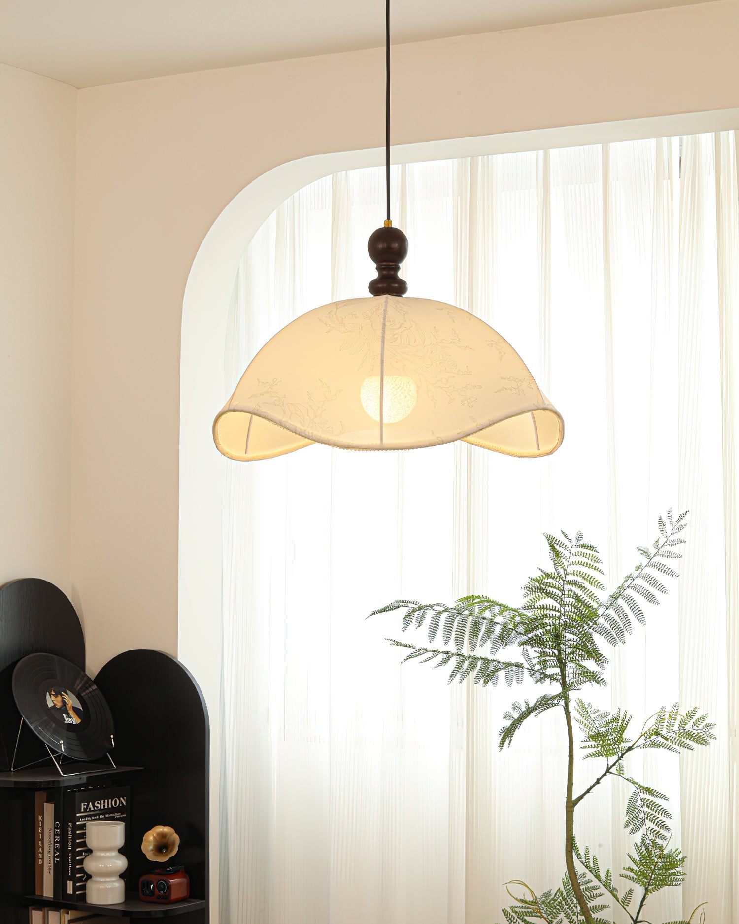 The pendant light hanging over a modern dining table.