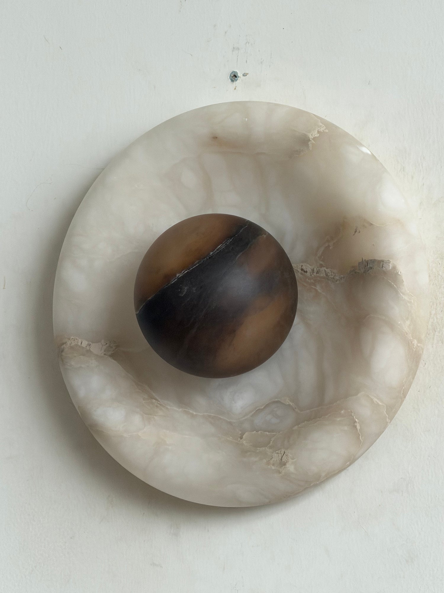 Orli Alabaster Wall Lamp installed above a bedside table.