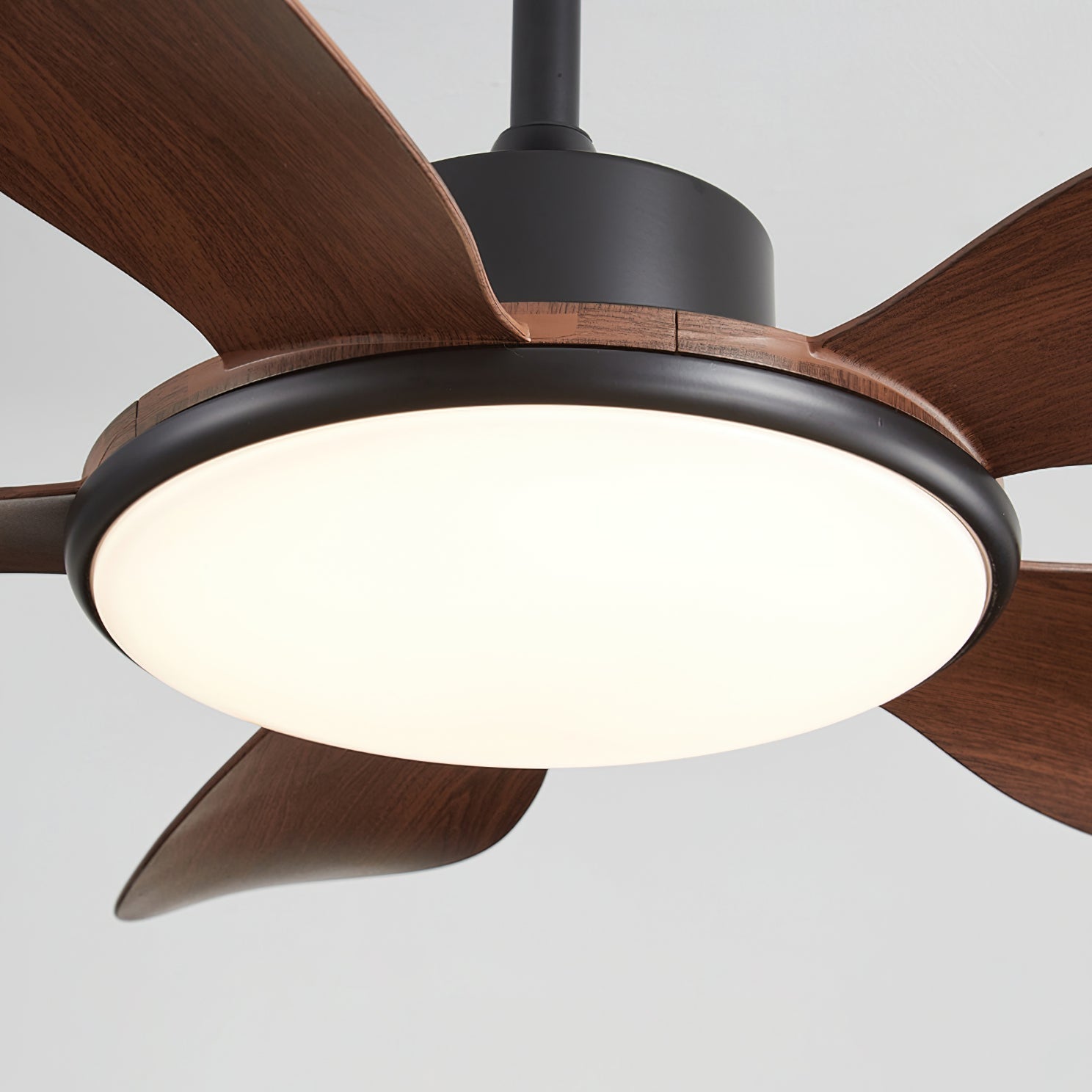Angled view of the white Ovlaim ceiling fan in a bright room.