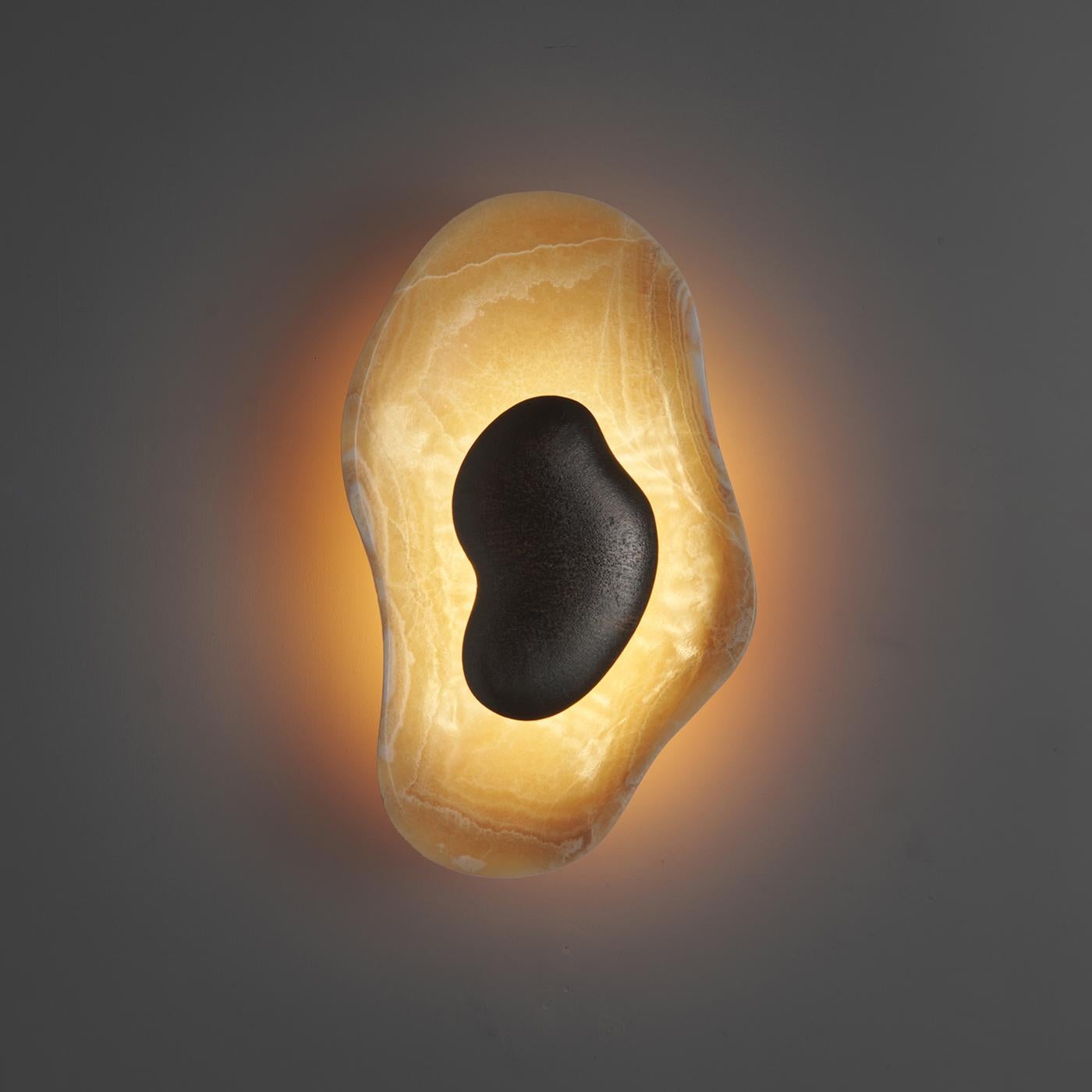 The sconce against a dark wall, creating a dramatic contrast.