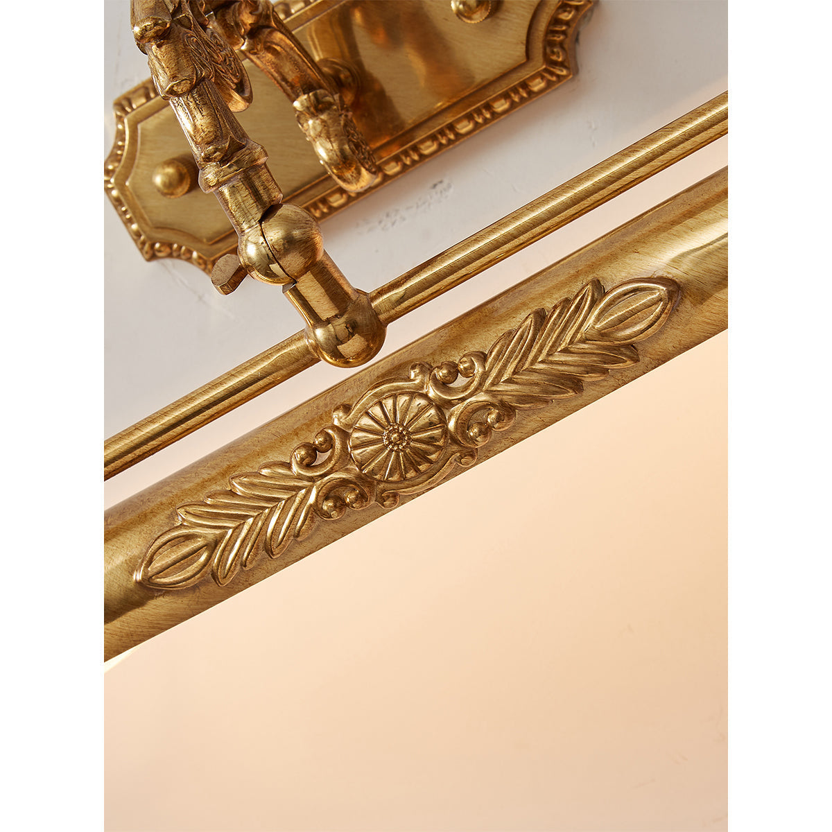 The hand-finished antique patina of the brass frame.