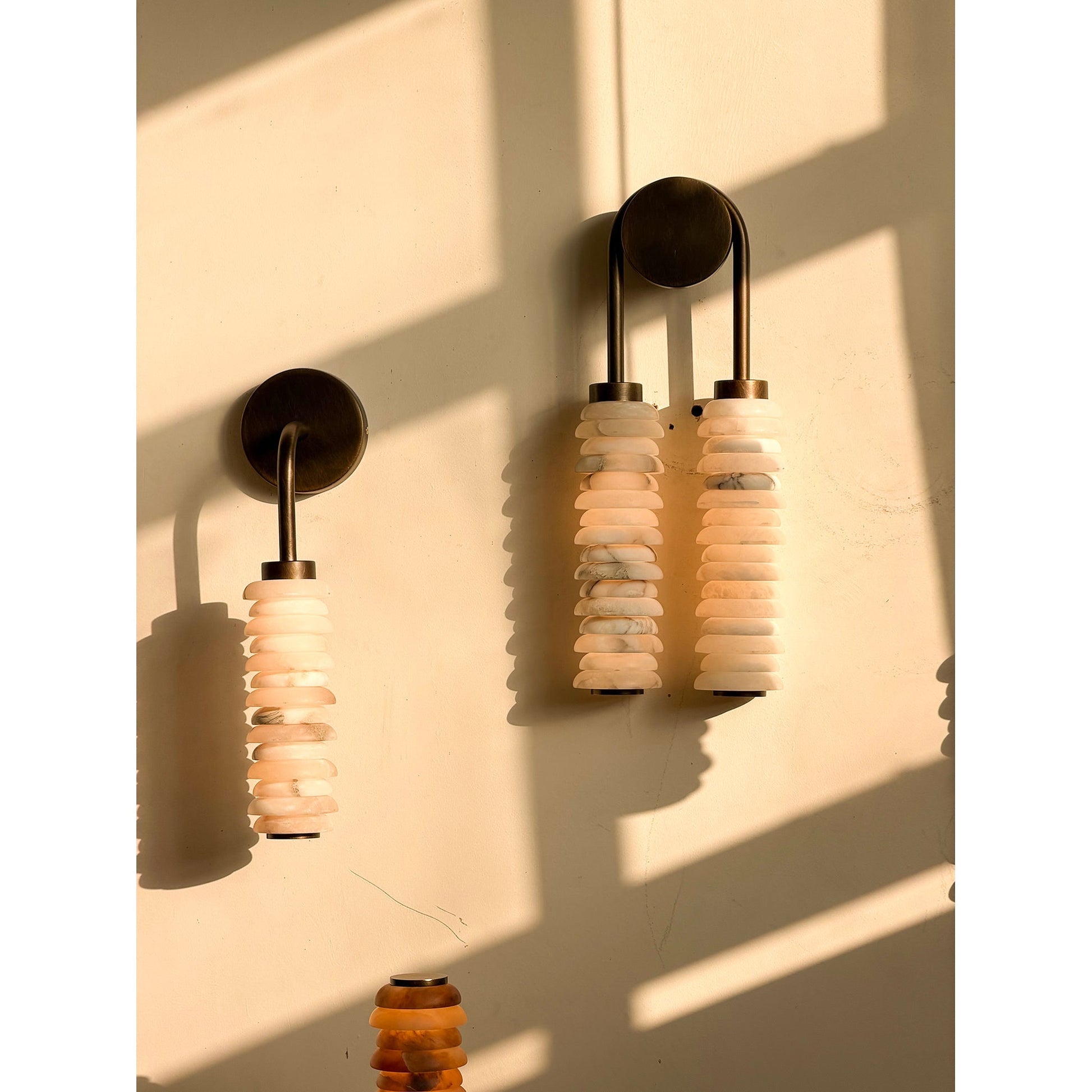 The wall lamp shown in a minimalist hallway.