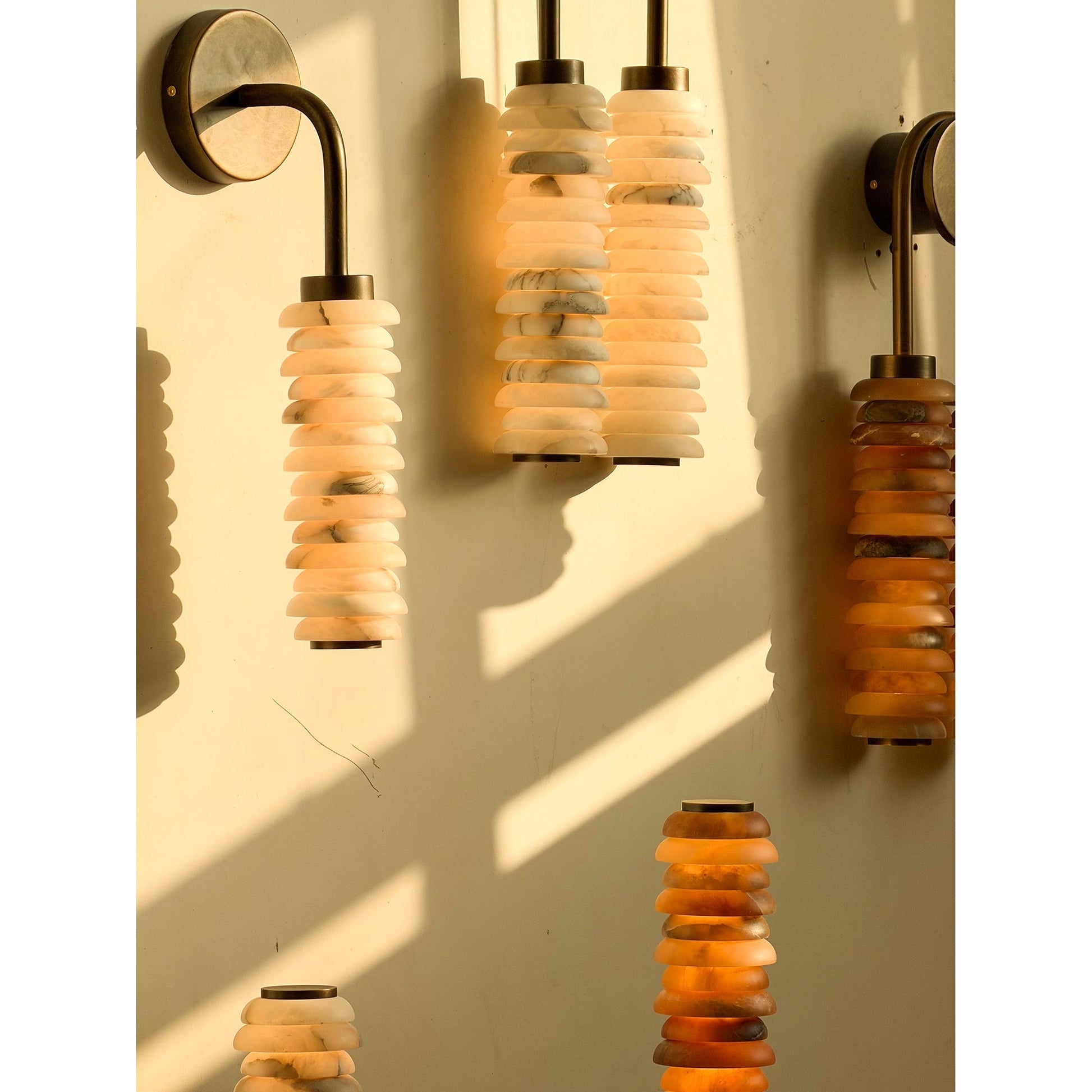The Payson sconce casting a soft glow on a textured wall.