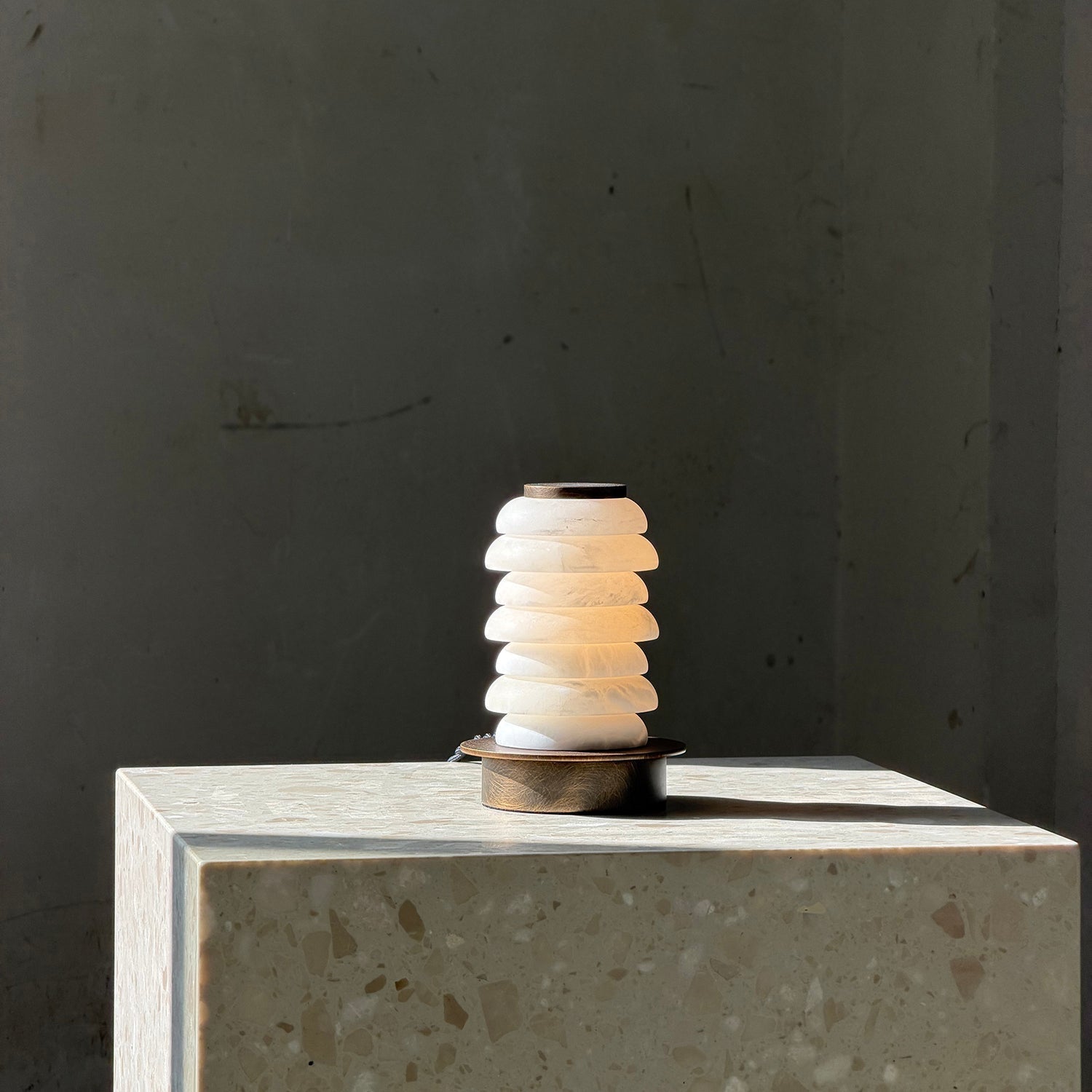 Payson Alabaster Table Lamp styled on a bedside table.