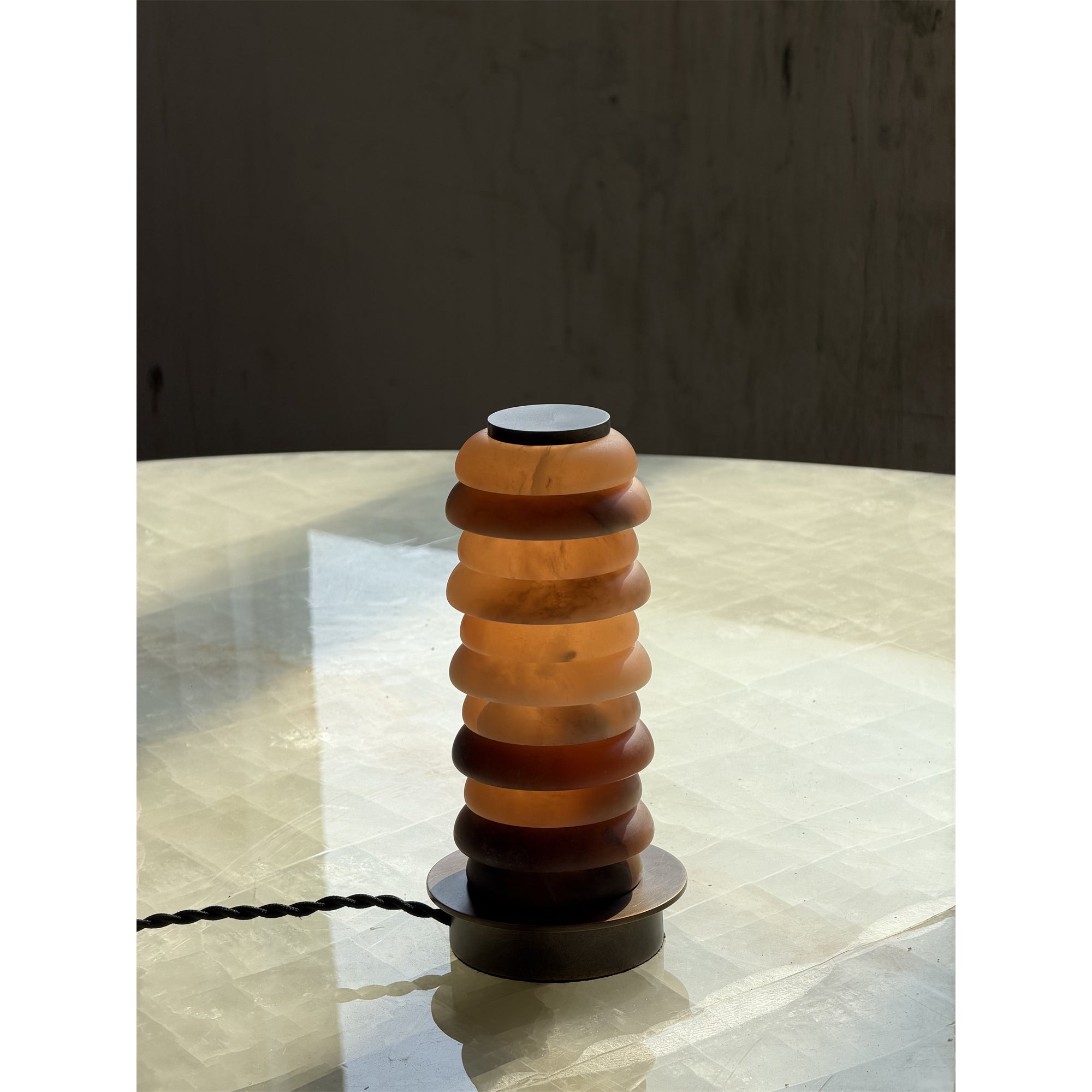 The lamp shown in a dark room to highlight its warm illumination.