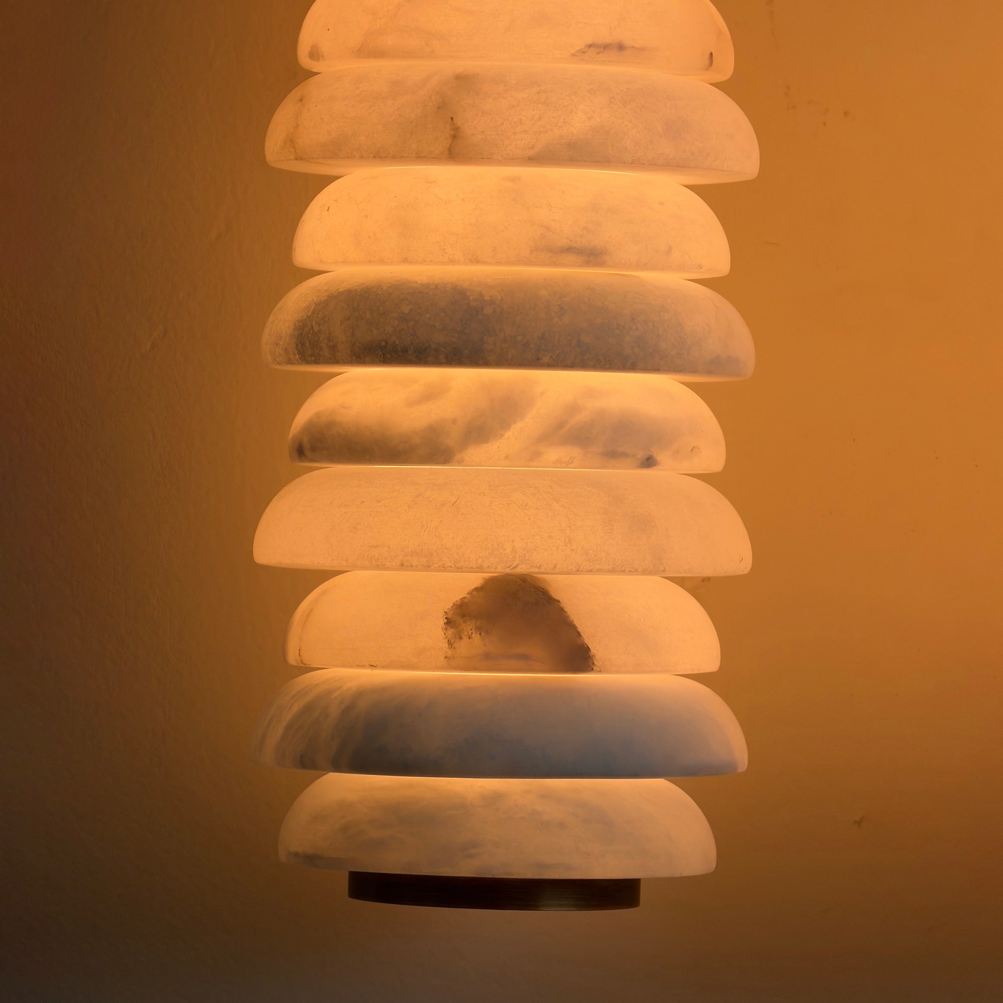 The Payson Wall Lamp emitting a warm, diffused glow.