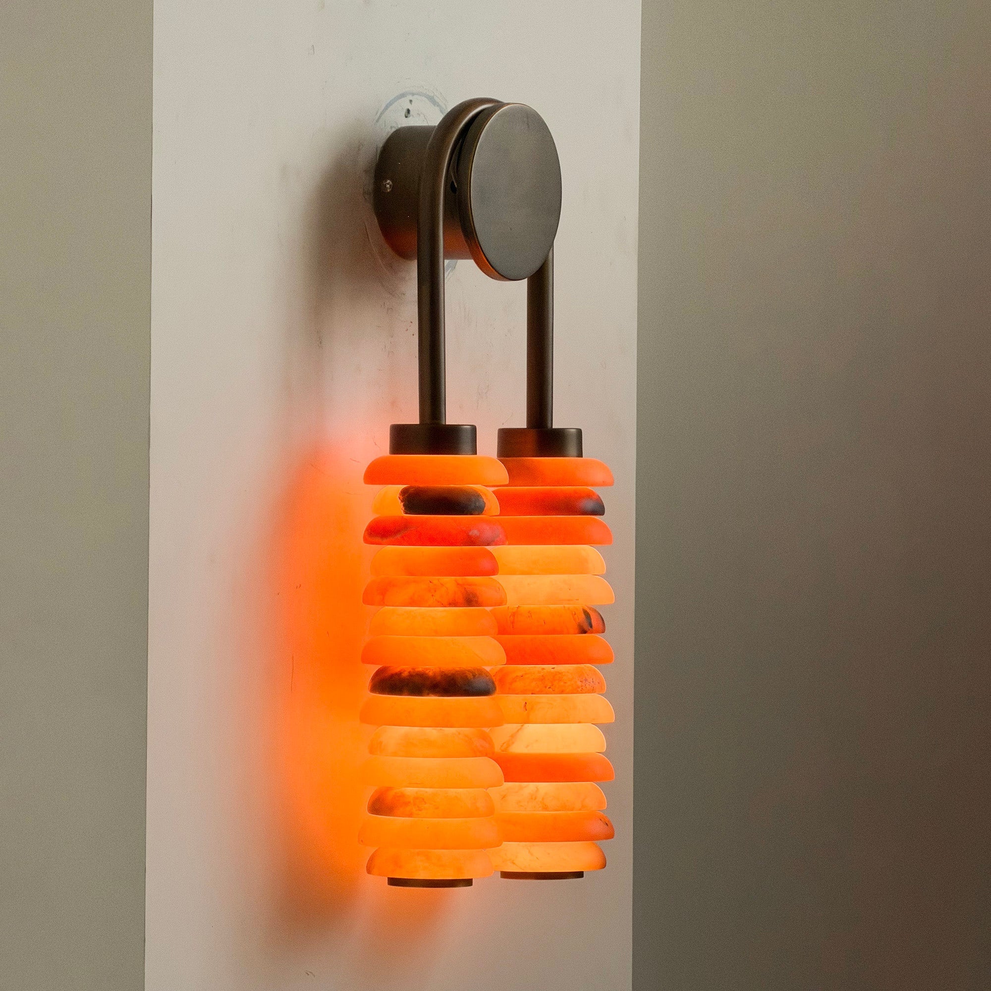 Lifestyle image of the wall lamp in a bedroom above a nightstand.