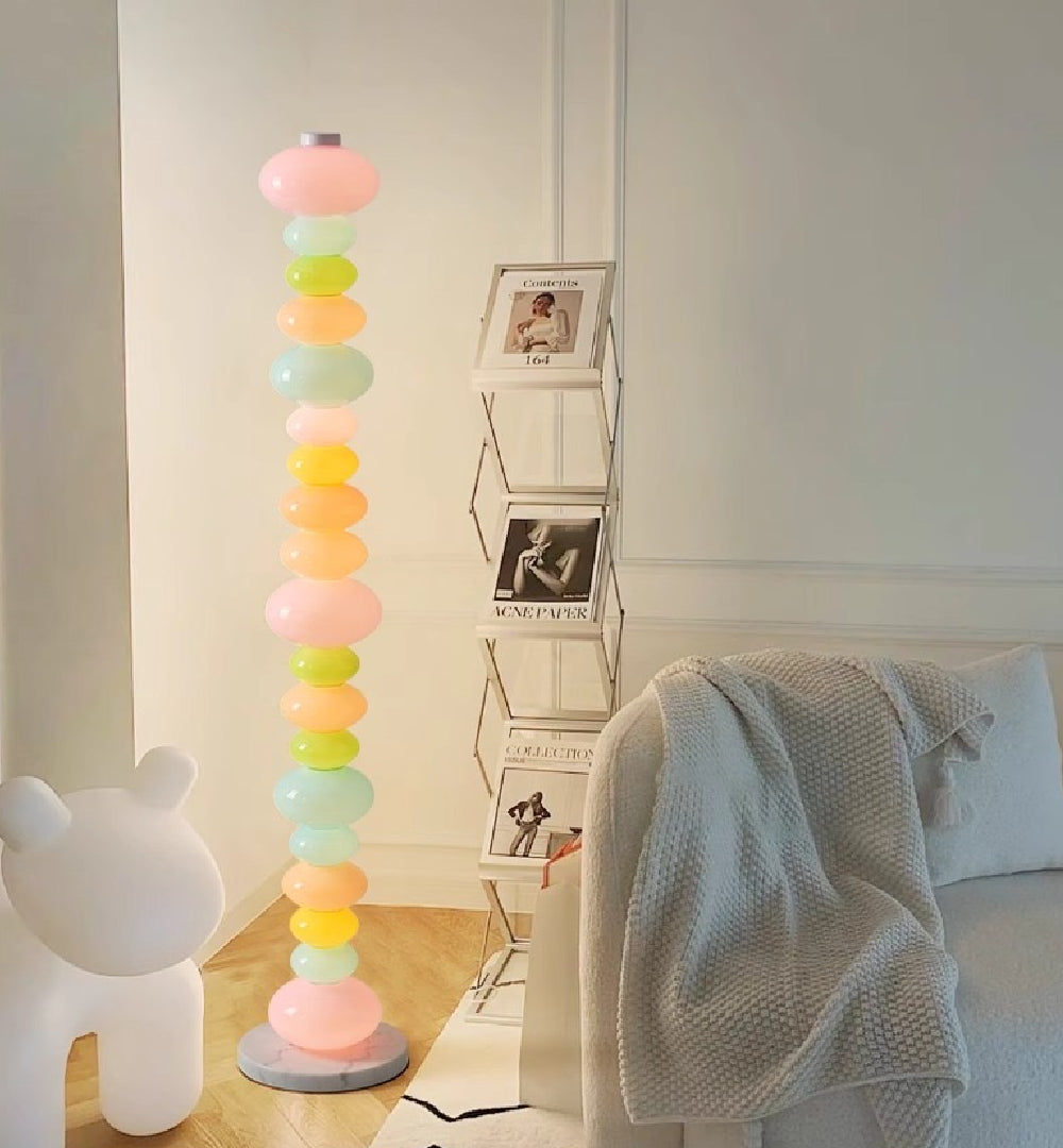 The Blue Pebbles Candy Floor Lamp illuminating a cozy reading corner.