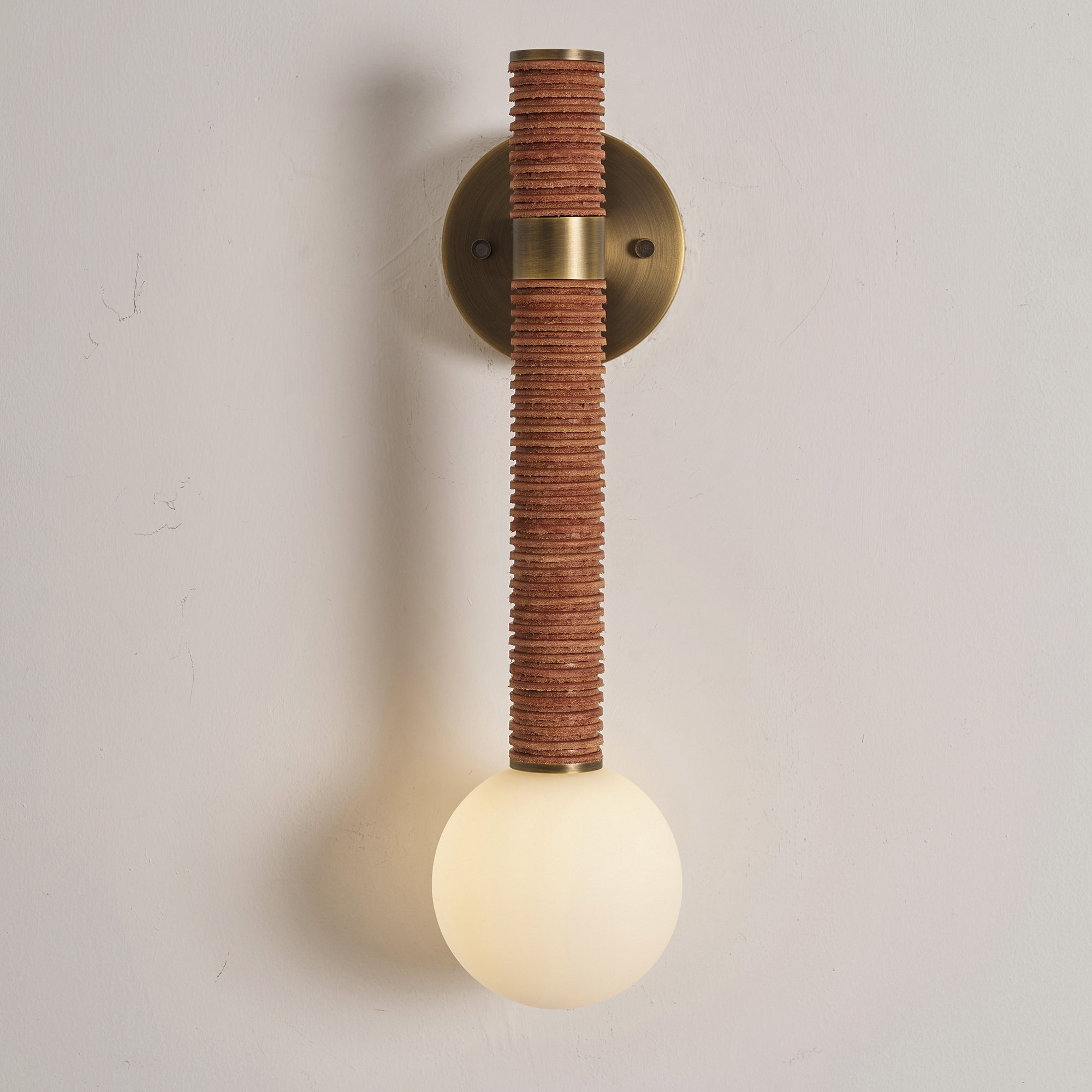 Lifestyle image of the Threadline sconce installed next to a bedside table.