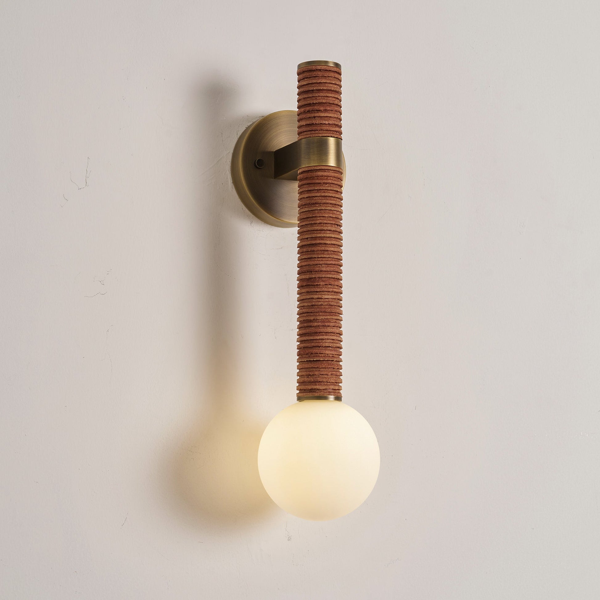 Angled view of the Threadline Globe Wall Sconce highlighting its vertical form.