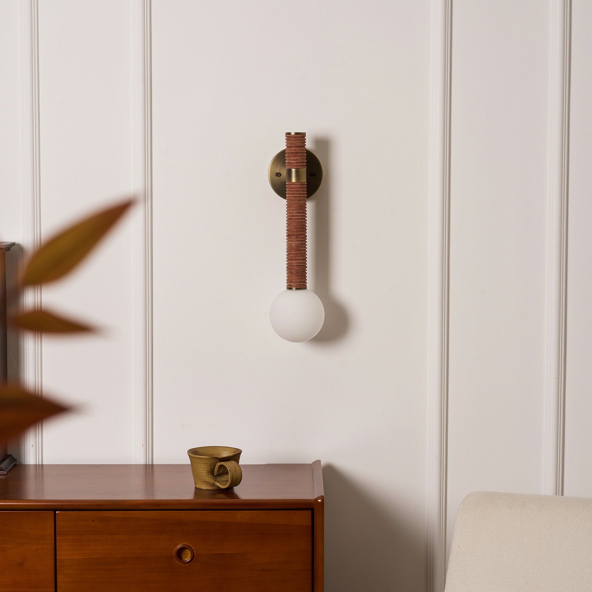 Threadline Globe Wall Sconce installed in a pair flanking an entryway mirror.
