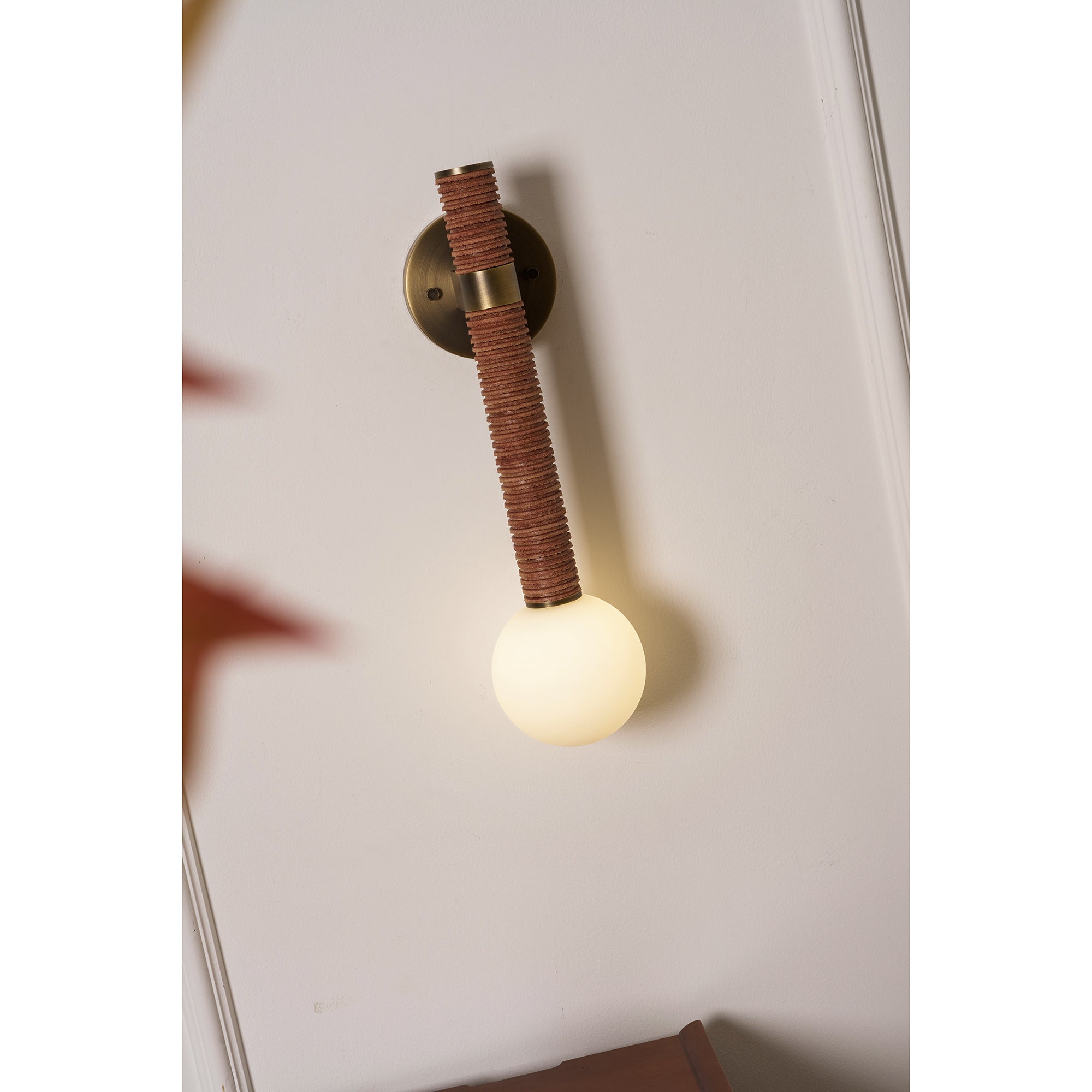 Detail shot of the antique brass backplate and white glass globe diffuser.