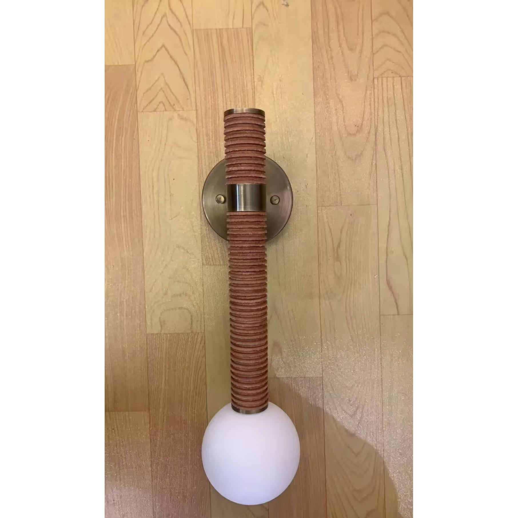 Threadline Globe Wall Sconce installed in a pair flanking an entryway mirror.