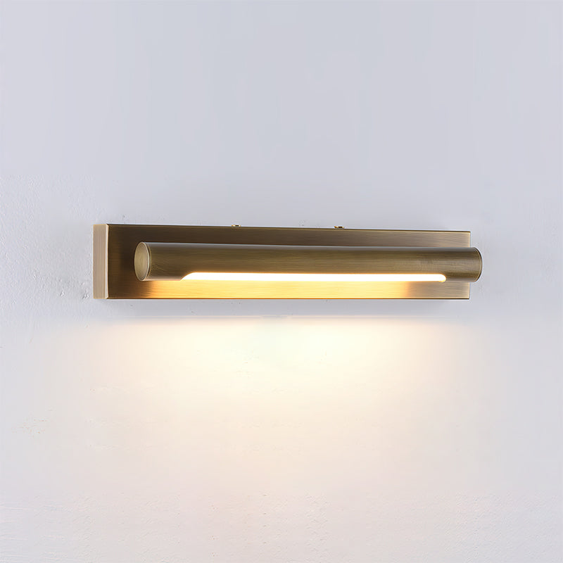 The Penrith Wall Sconce in antique brass finish against a dark wall for contrast.