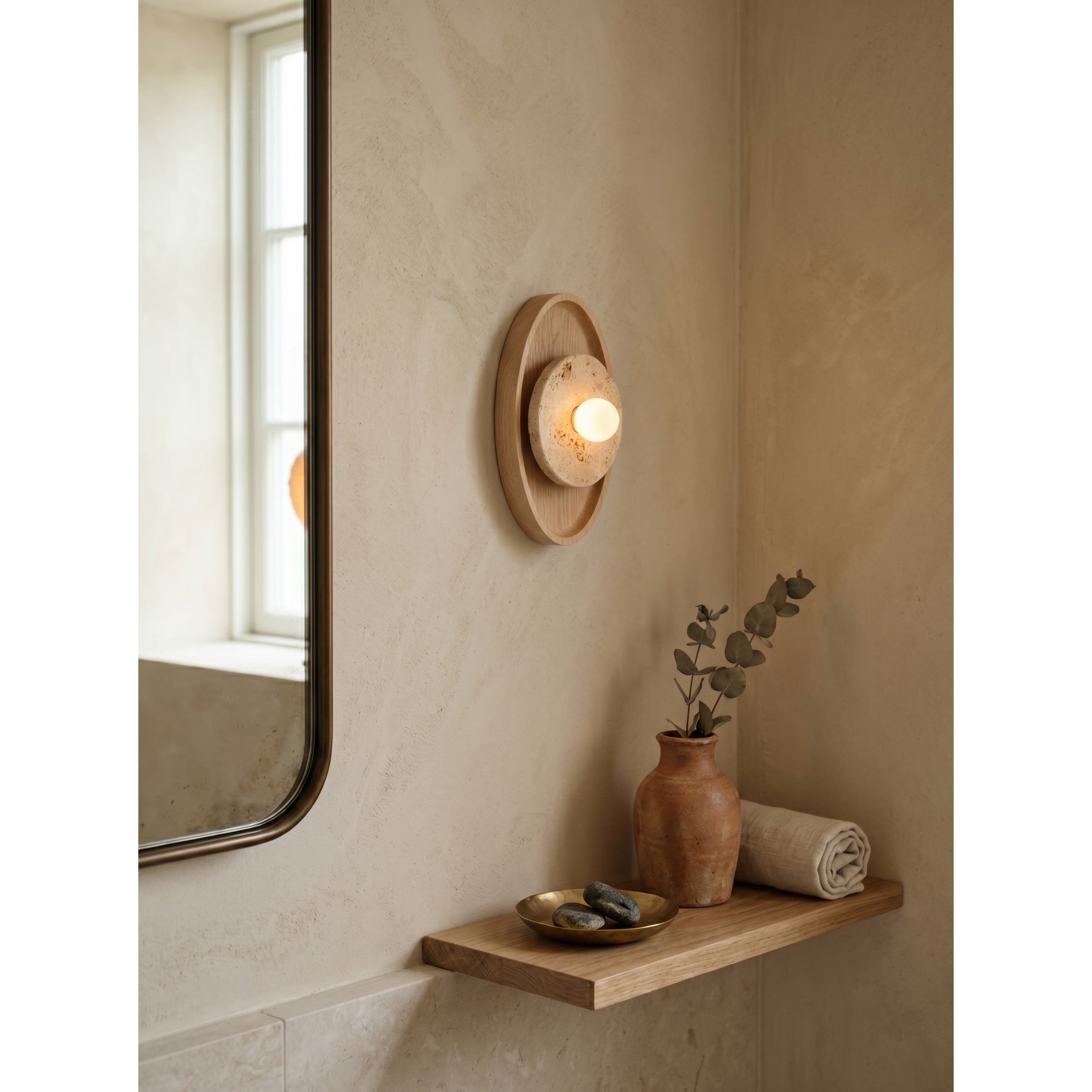 The sconce shown against a dark wall to highlight its form.