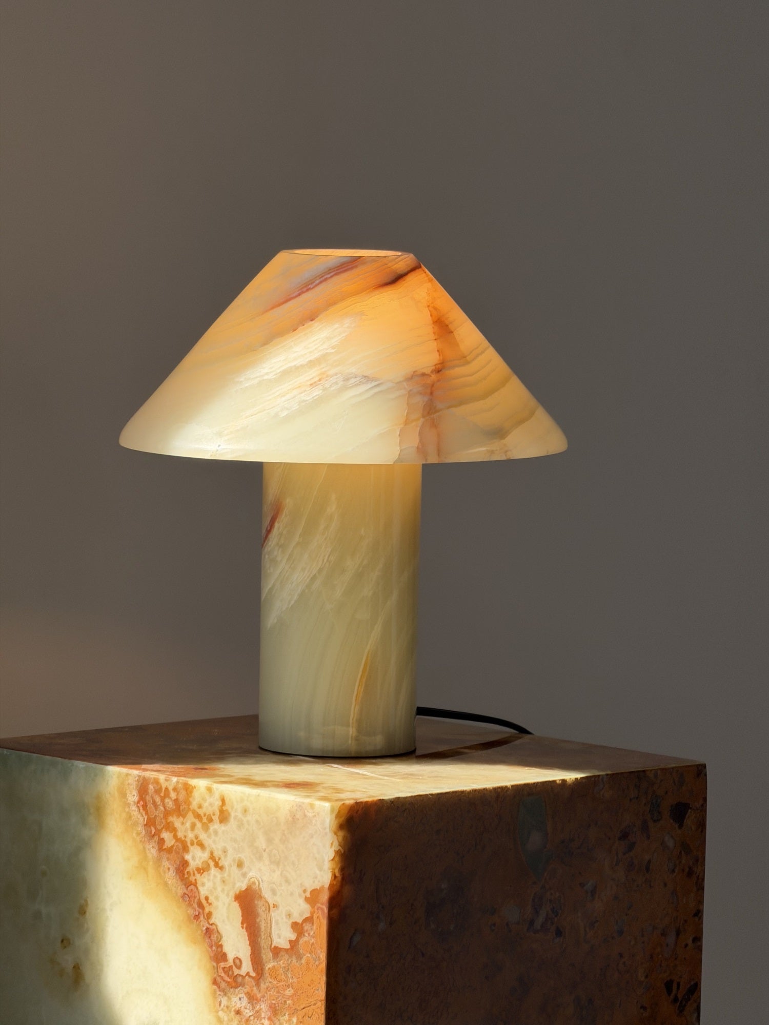 The lamp shown lit in a dimly lit room.