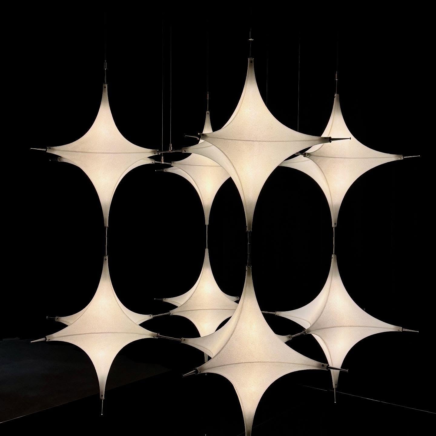 The single-head Polar Chandelier shown in a minimalist bedroom setting.