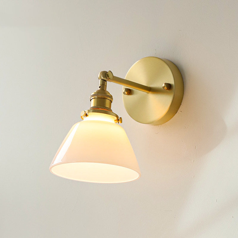The wall sconce shown in a bedroom setting next to a bed.