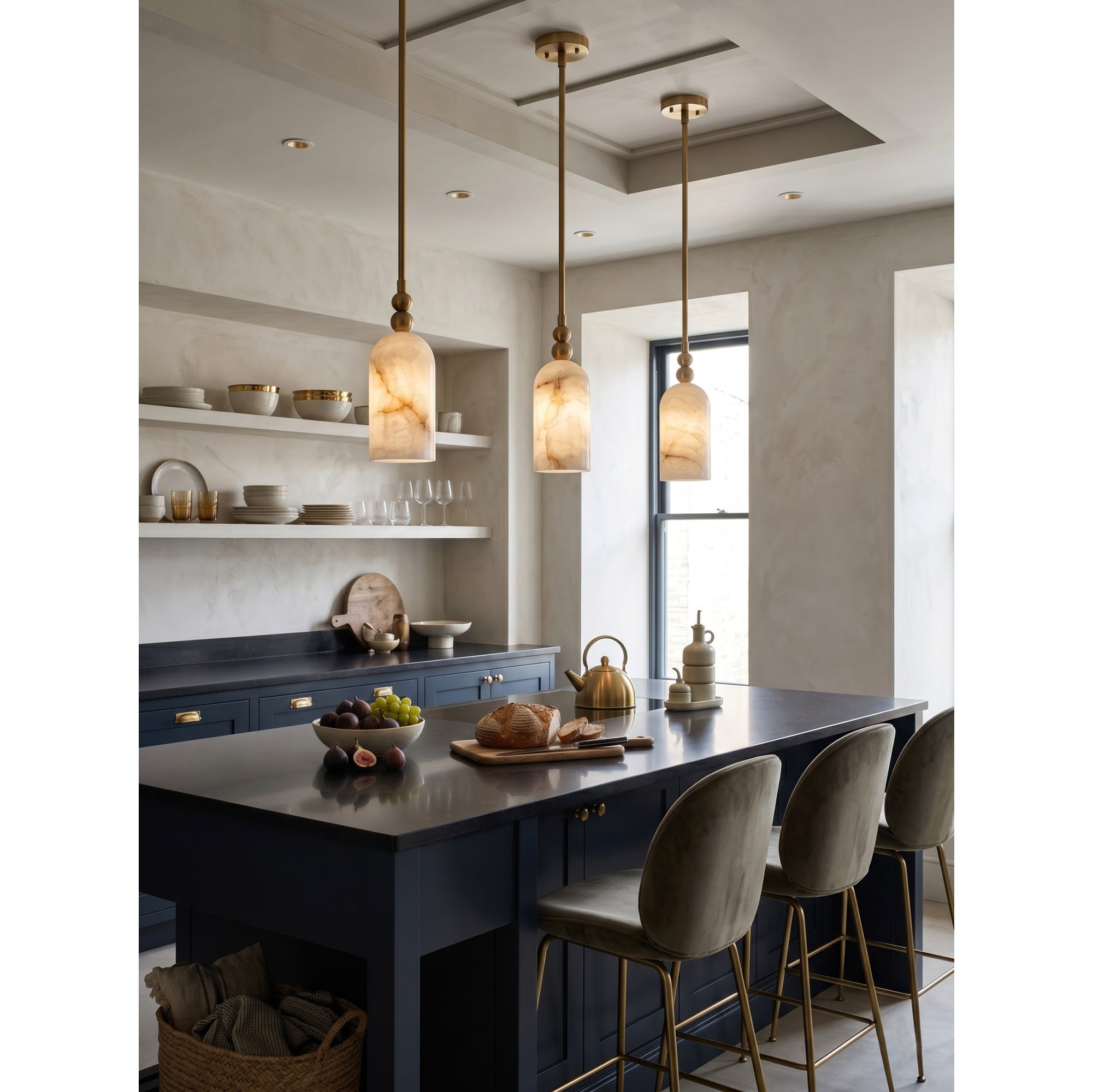 A row of three Pratt pendants over a long kitchen counter.