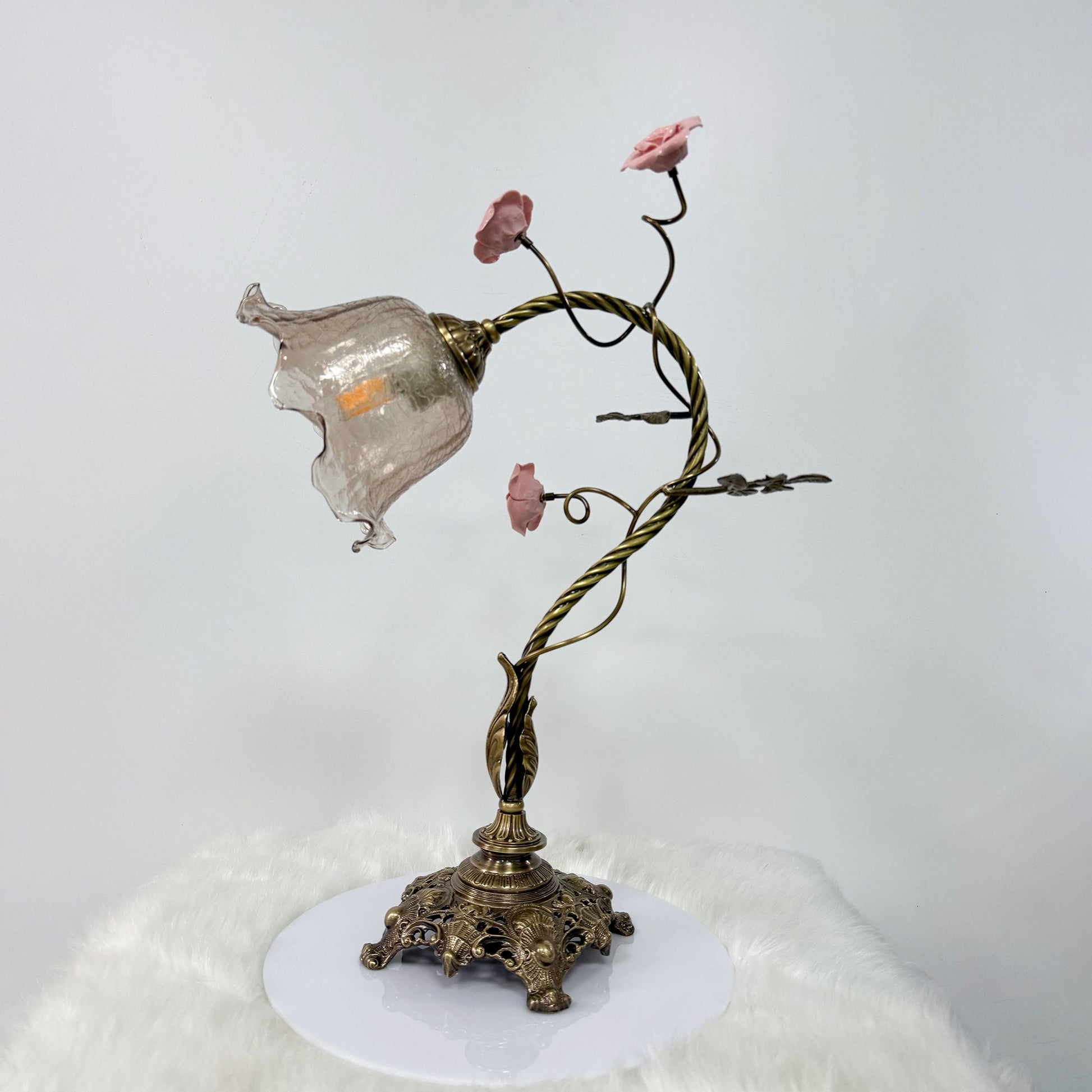 Primavera Flowers Table Lamp illuminated, casting a warm and inviting glow.